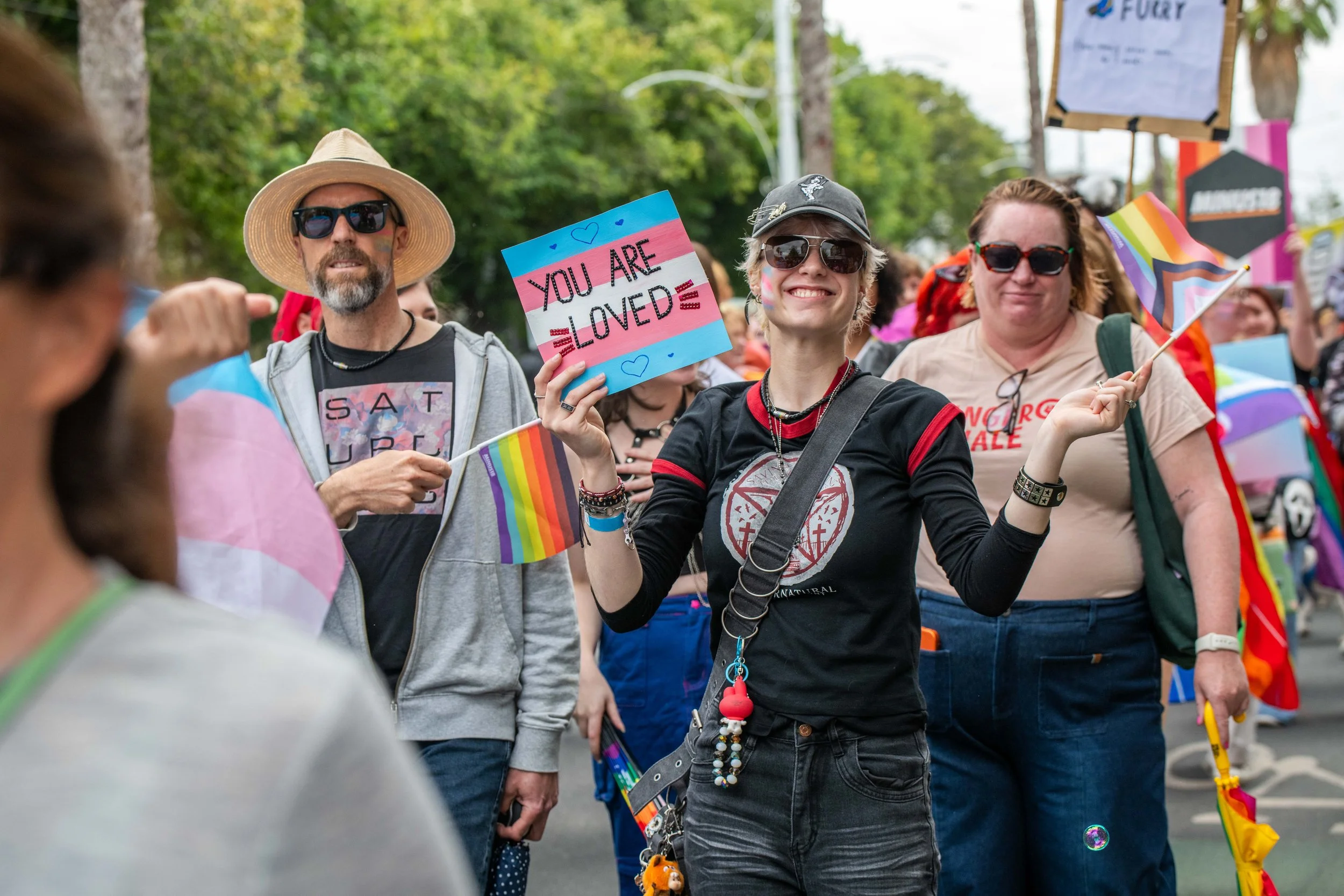 A human holding a sign "You are loved".