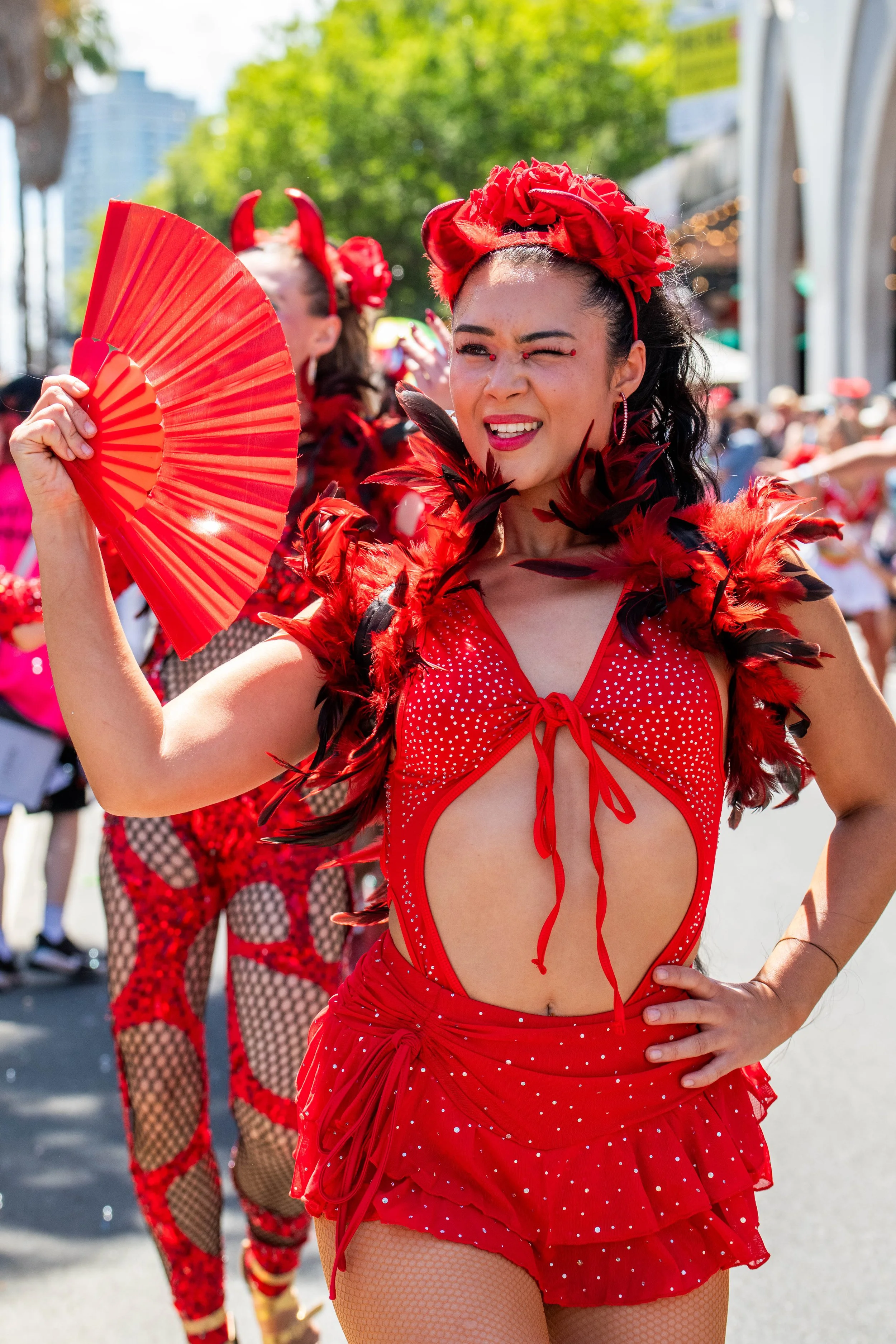 A latino dancer in red winks at the camera.