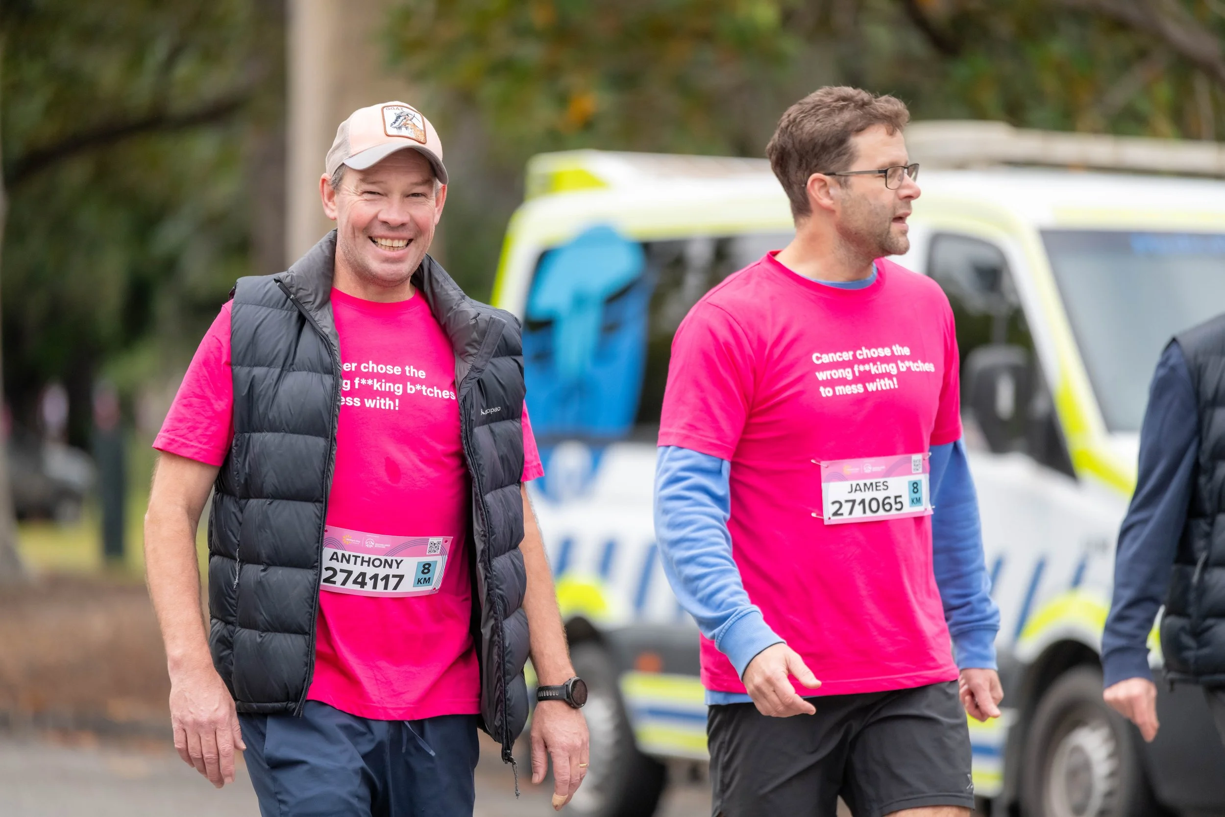 Two racegoers wearing pink memorial tees.