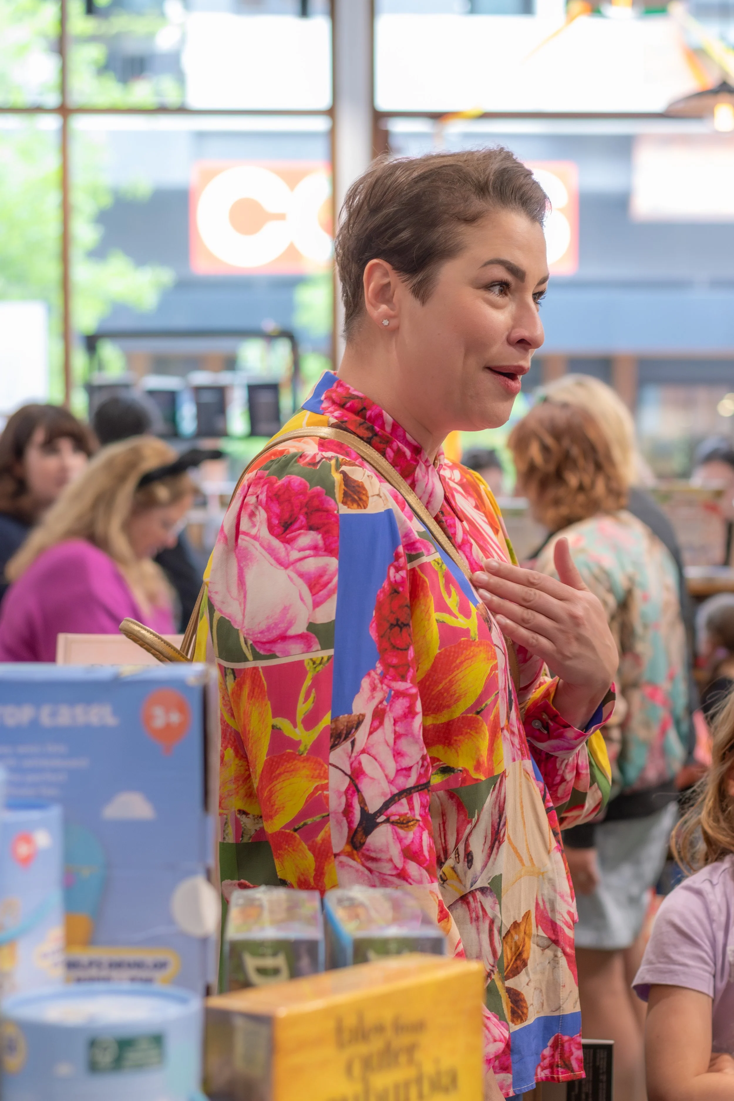 A human gesticulates at themself whilst chatting.