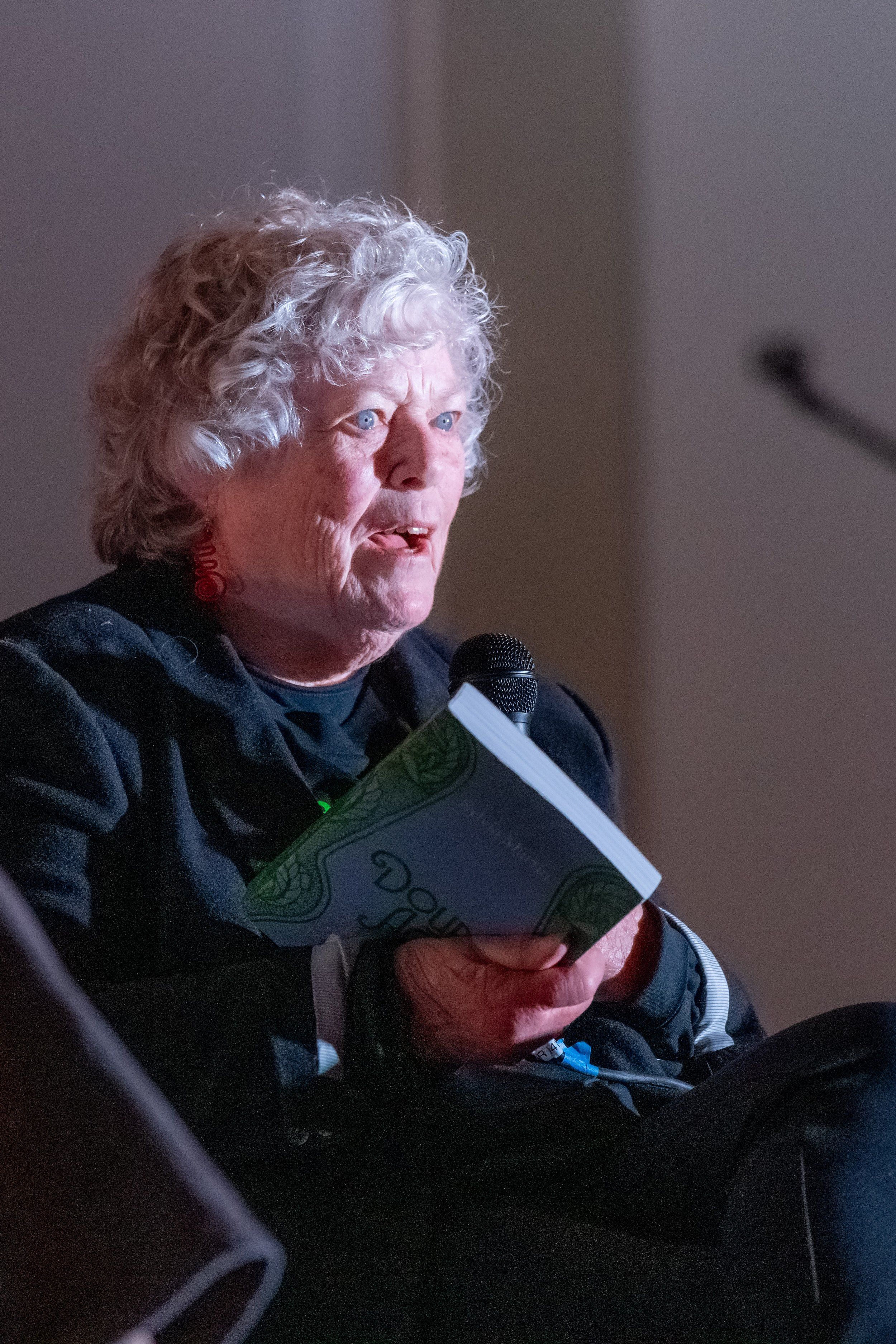 Syliva Martin holds a book and speaks.