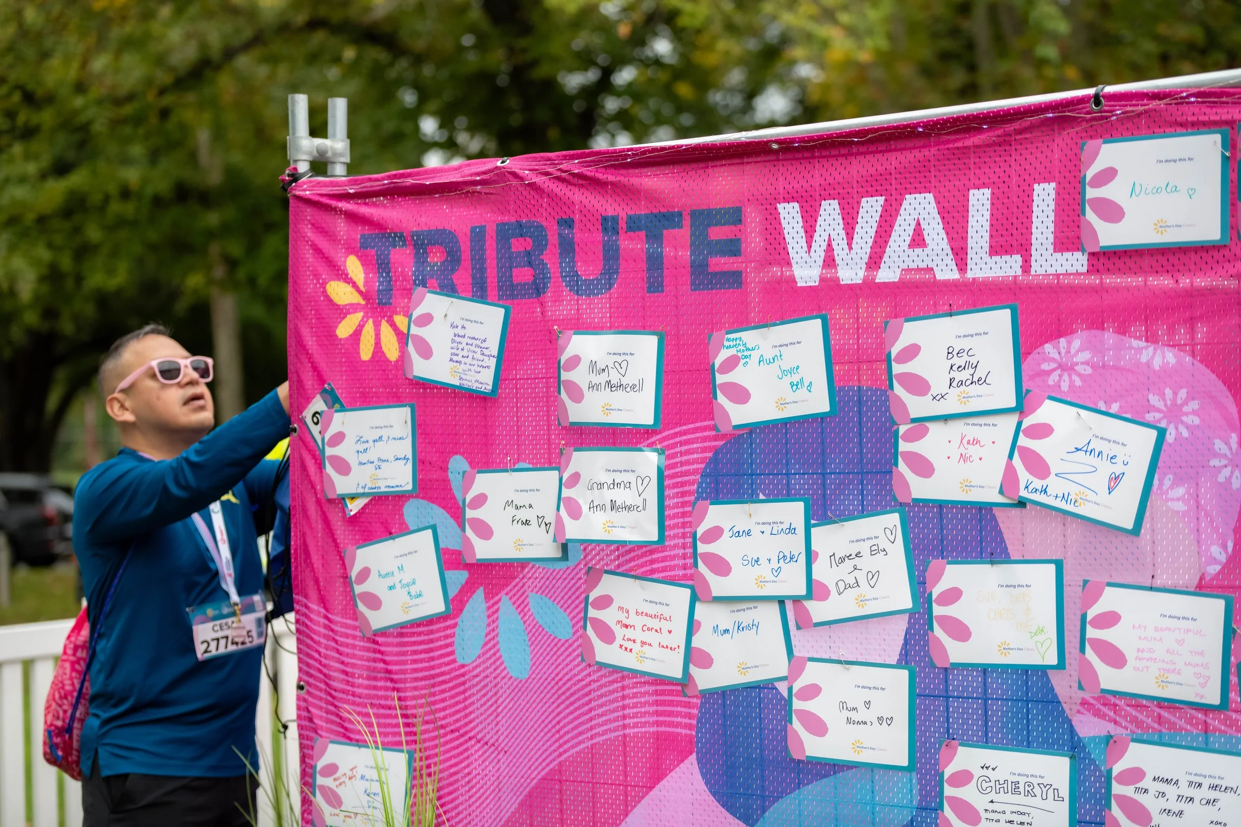 A racegoer pins a note to the Tribute Wall.