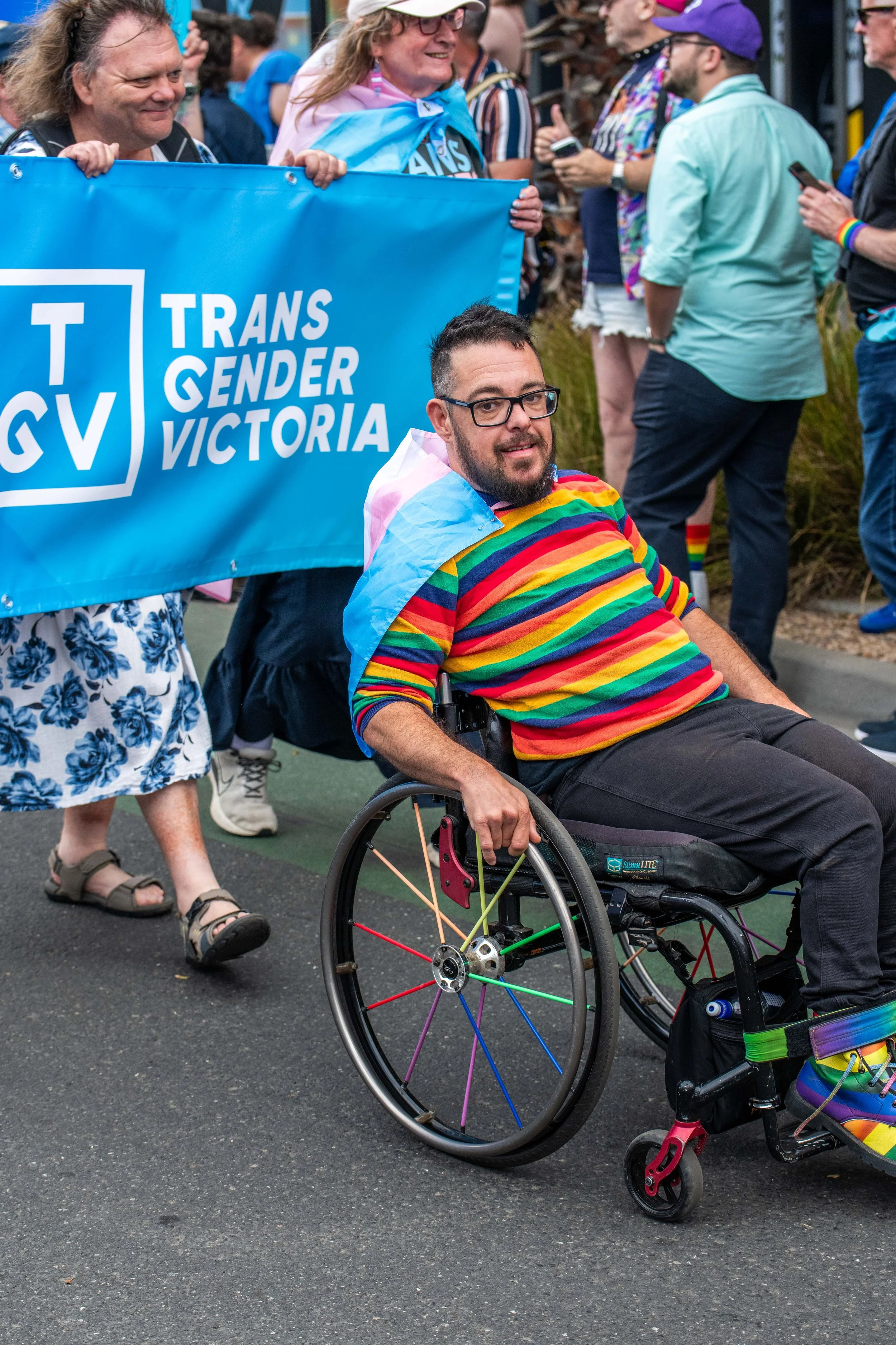 A human in a wheelchair marching with Trans gender Victoria.