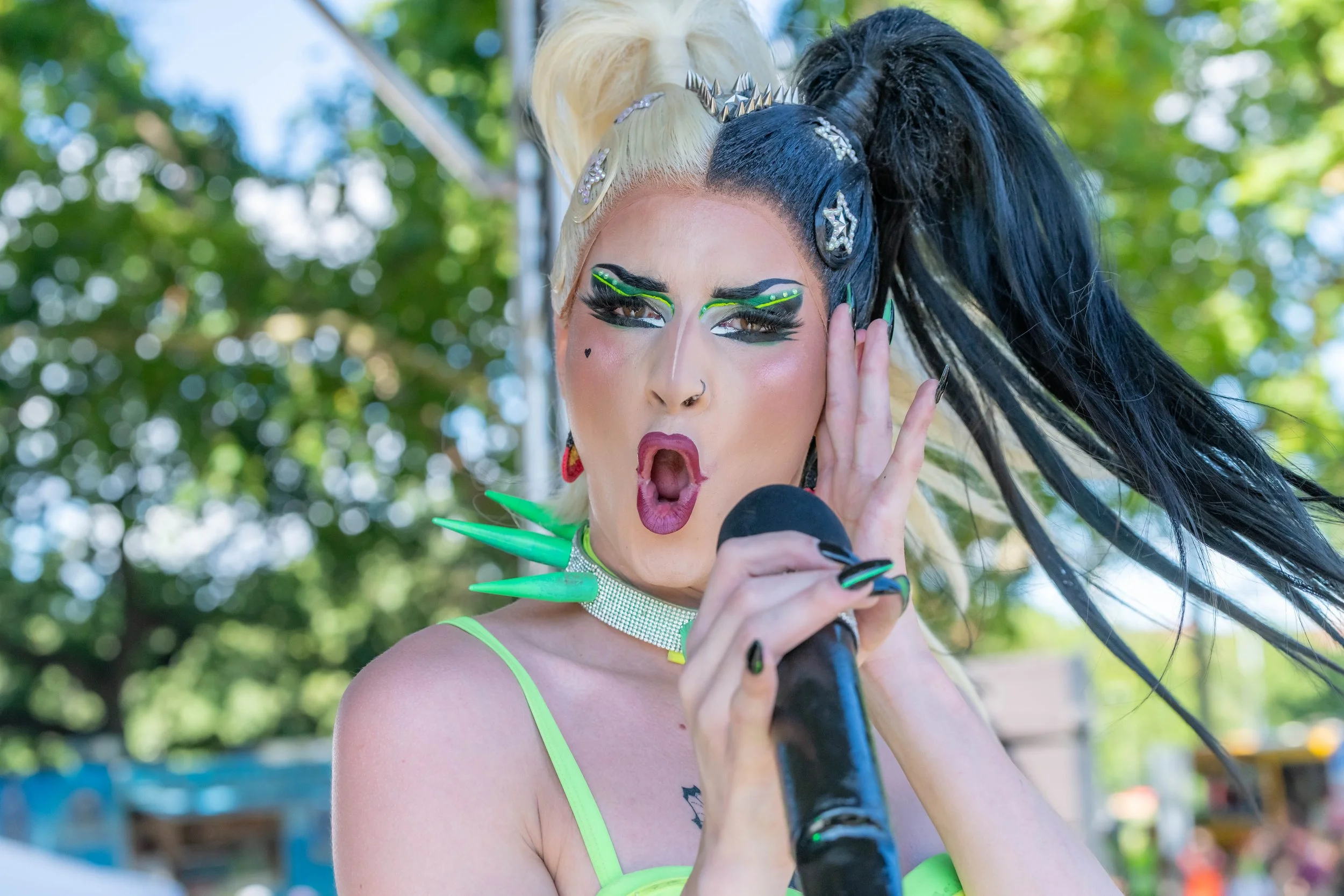 A drag queen with blond and black split wig hams it up for the camera.