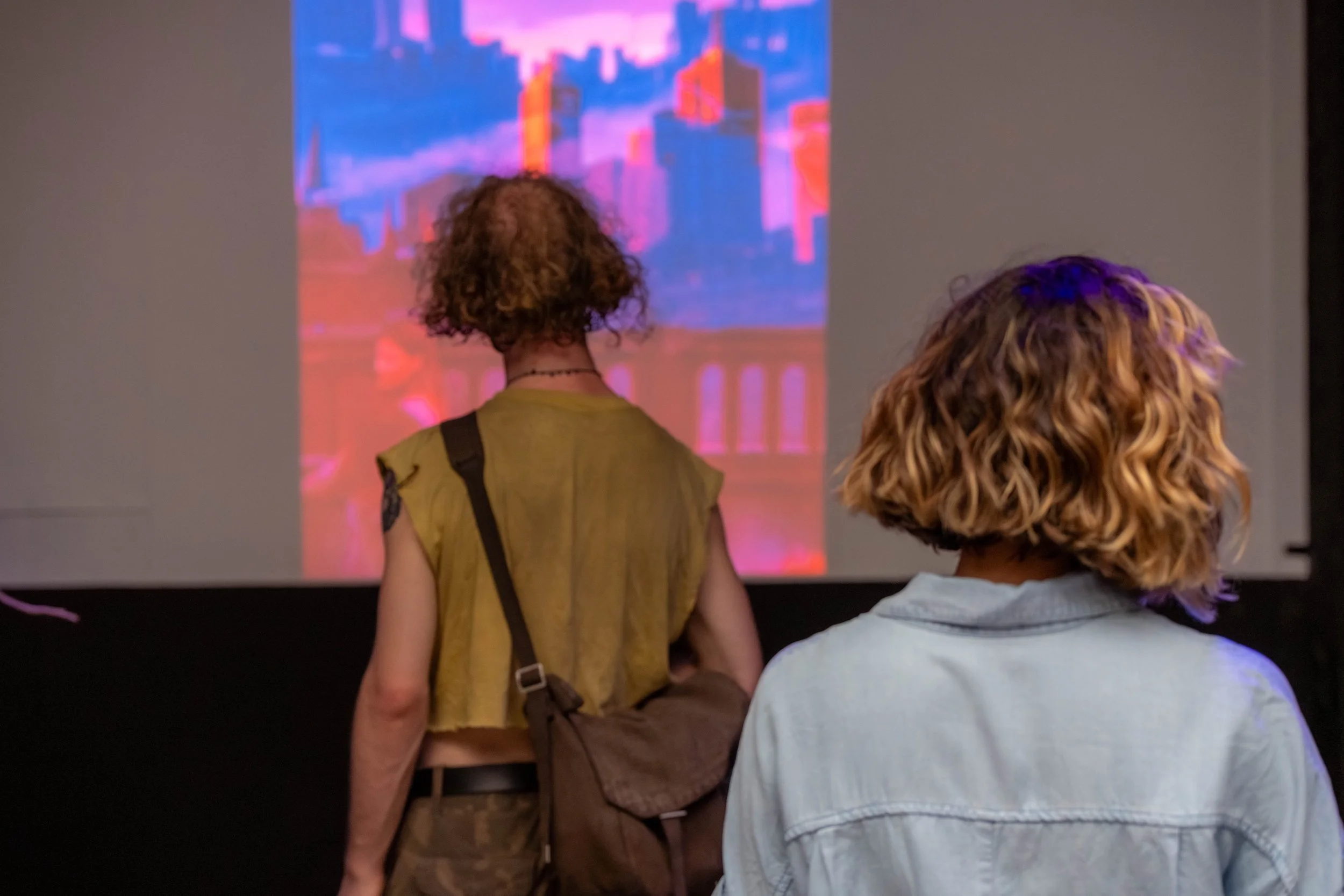 Humans watch a projection playing.