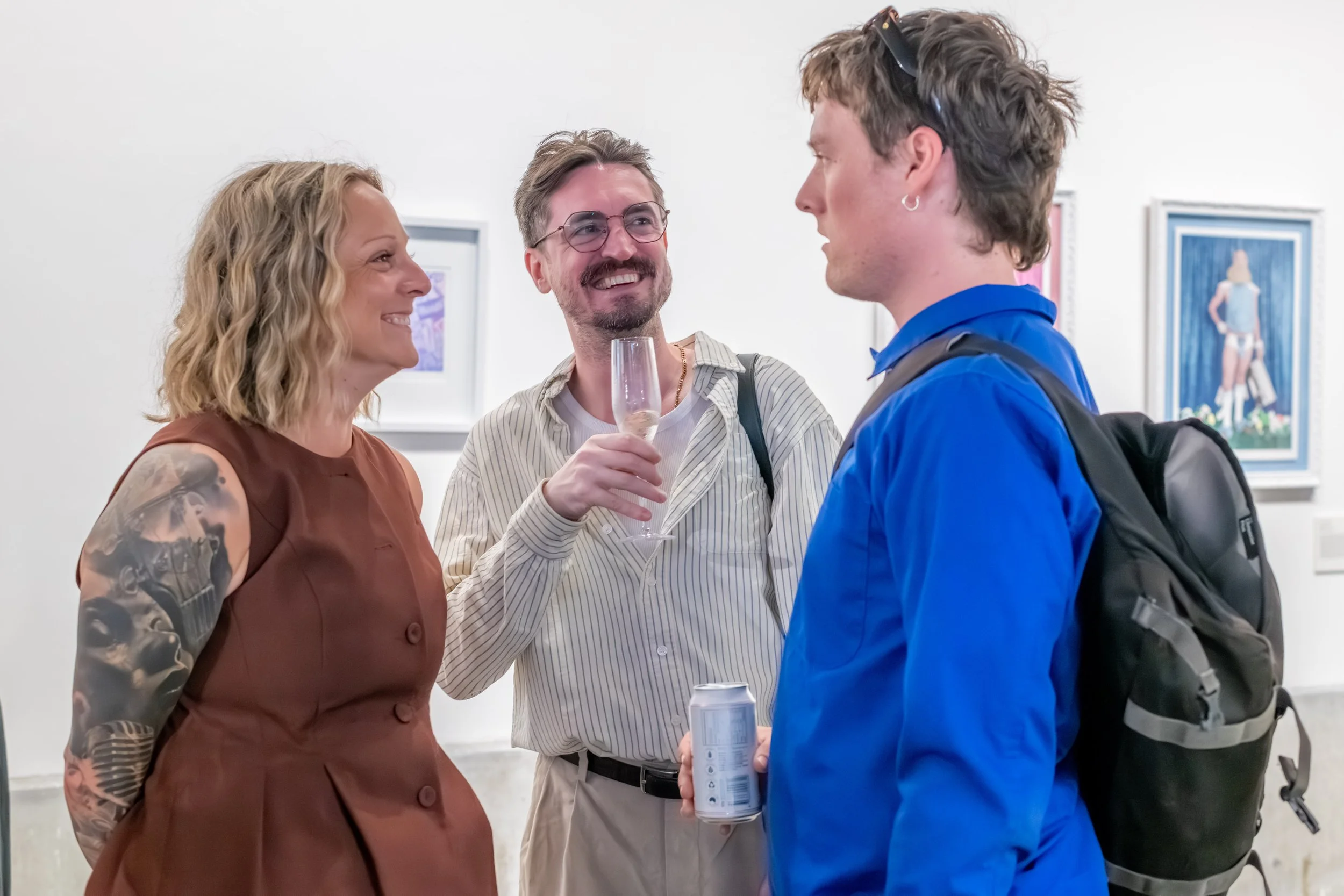 Three humans smile and chat with each other.