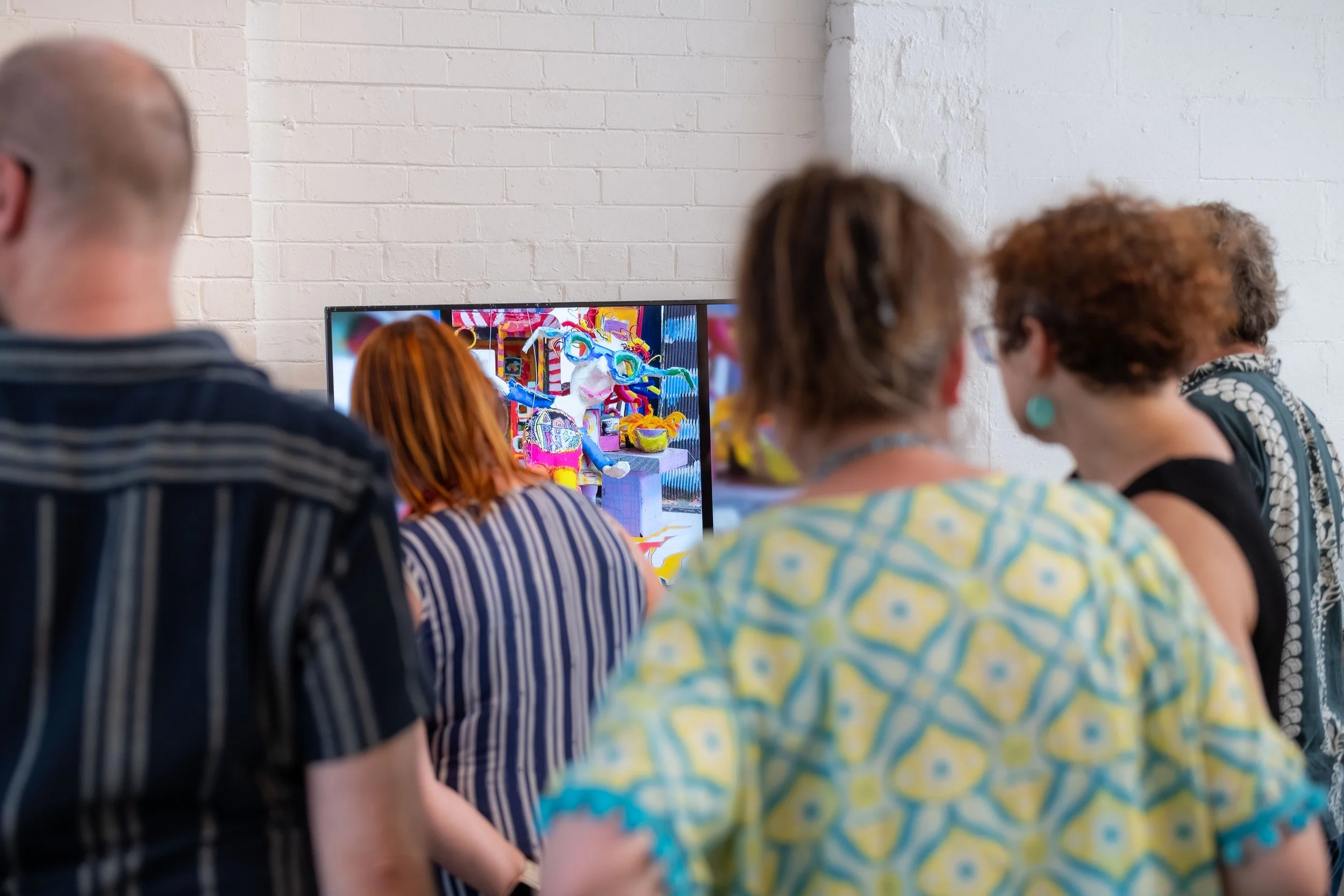 Many people look at a video playing.