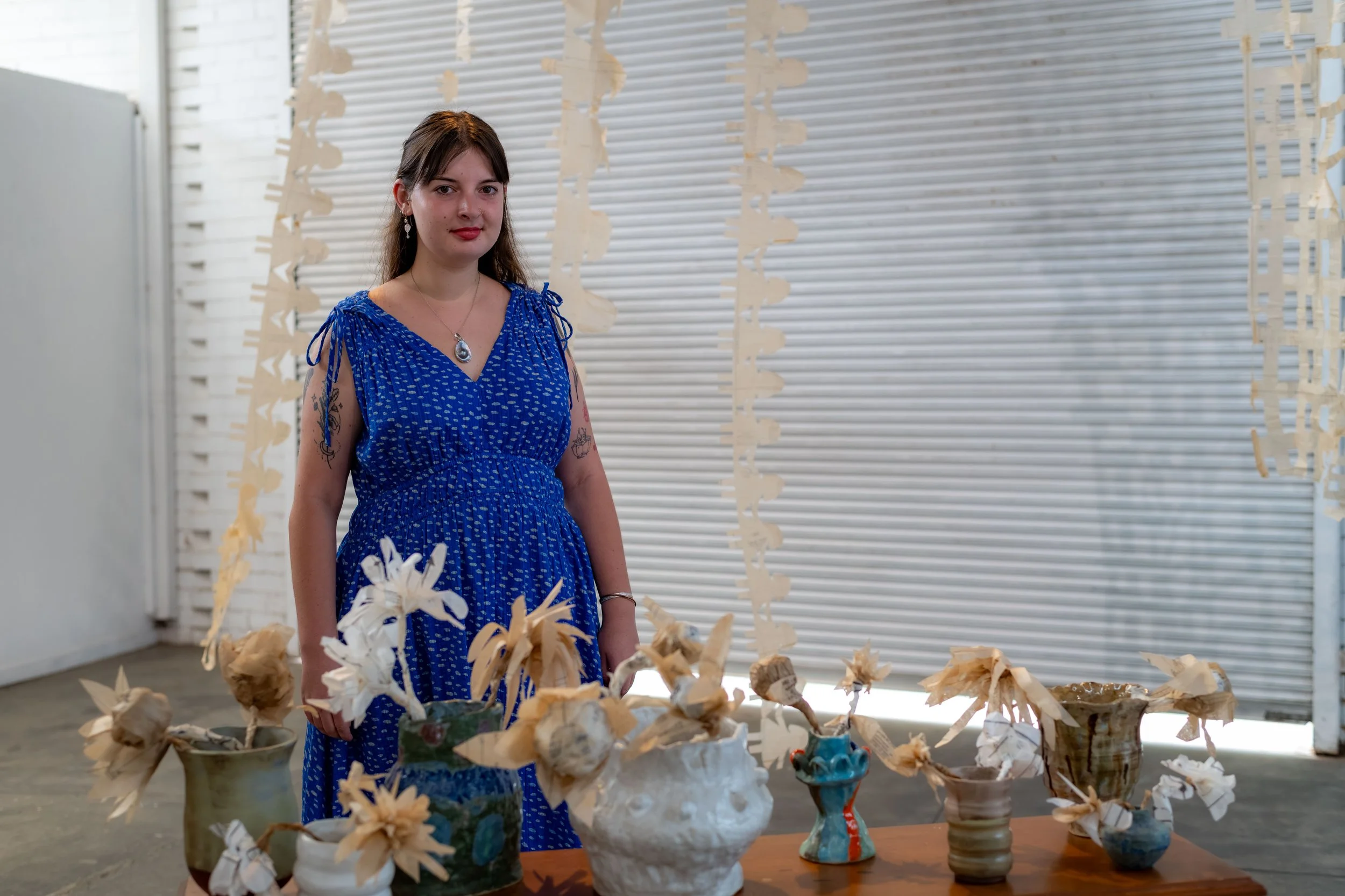 Nina Fitzsimmons poses with their sculptures.