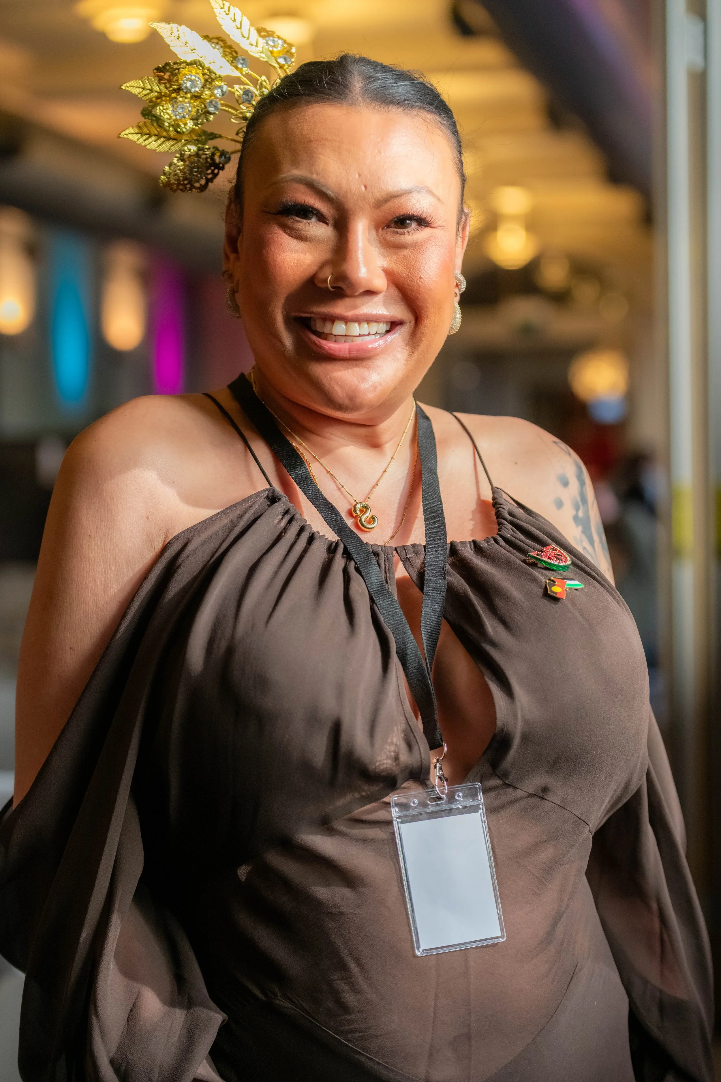A human in a brown dress smiles at the camera.