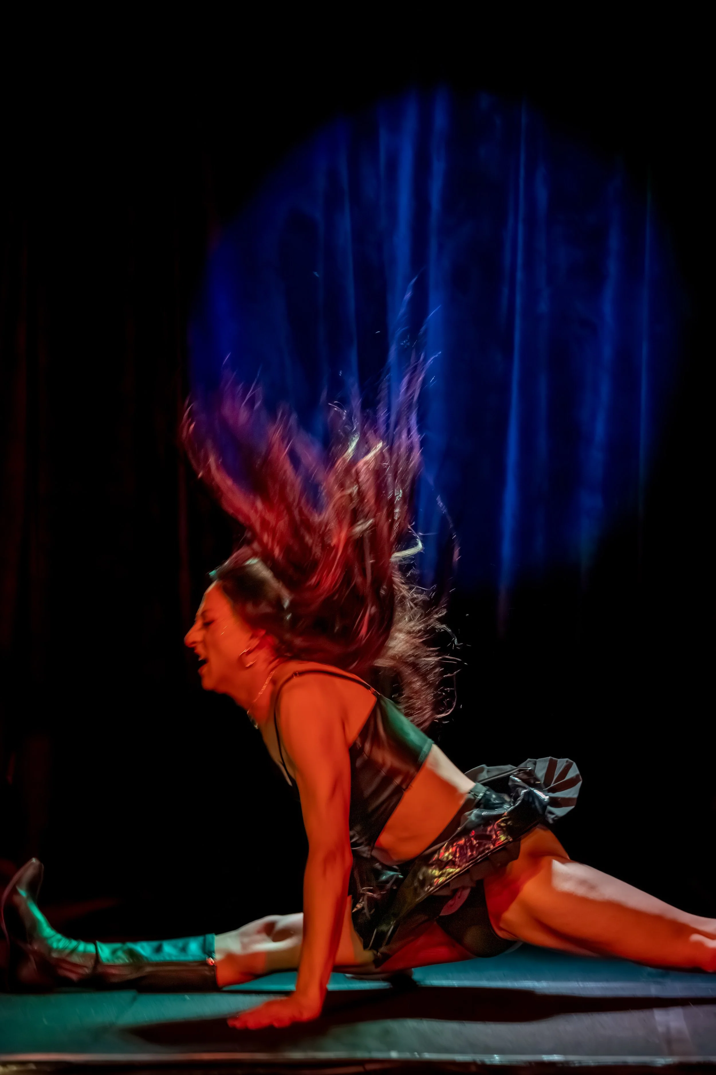 A drag queeen drops wuickly into the splits.