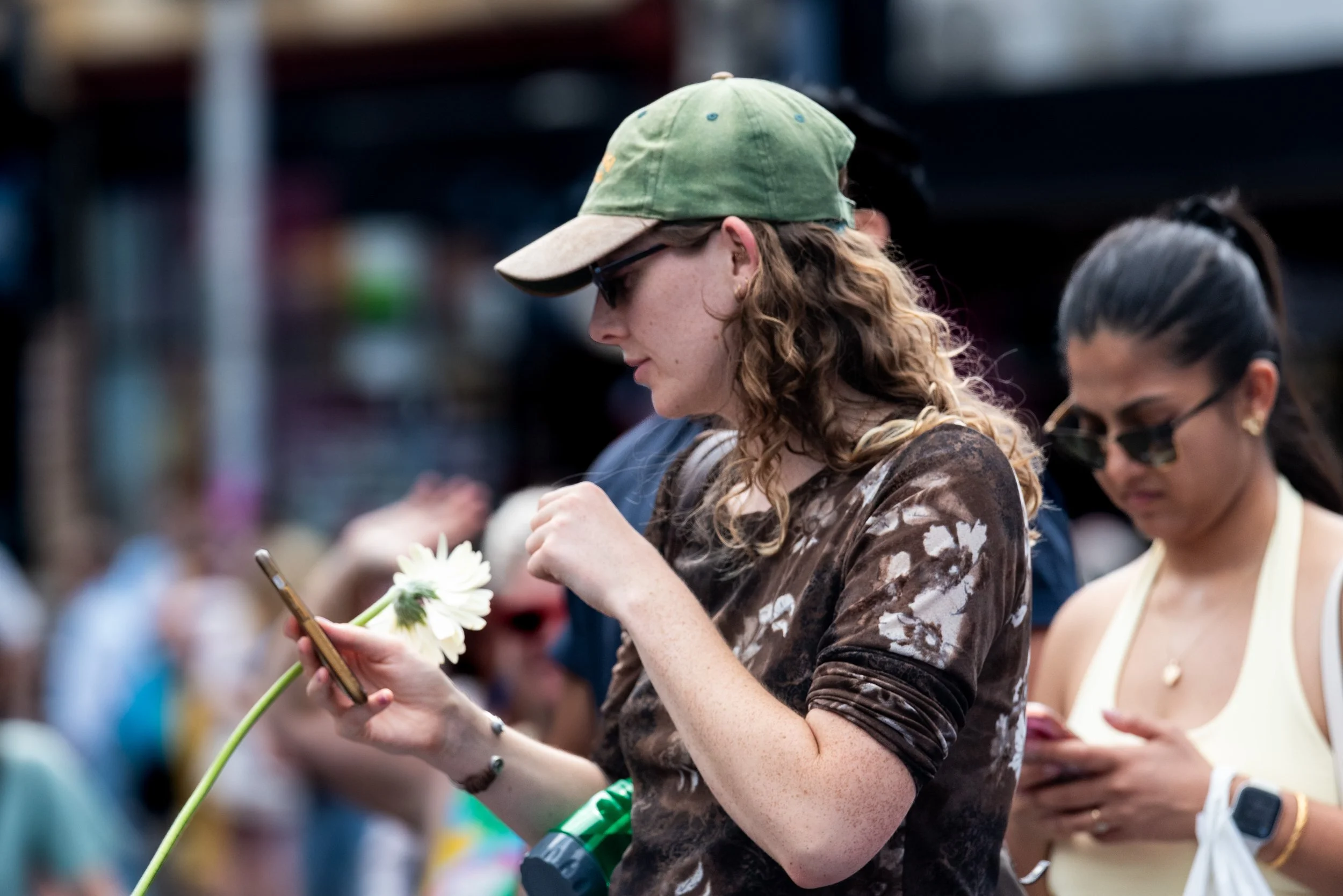 An audience member looks at their phone and holds a flower.