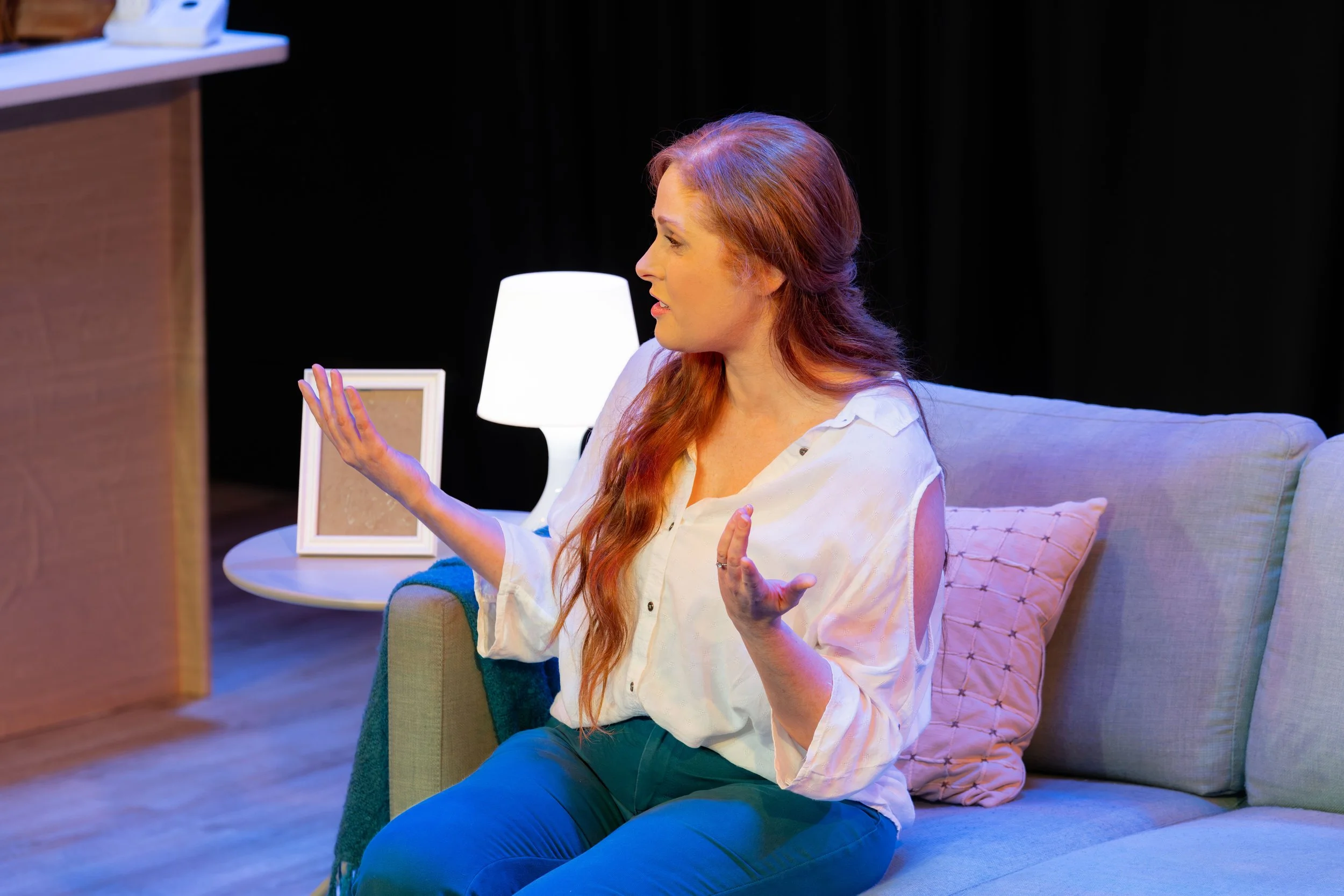 A human with long hair gesticulates.