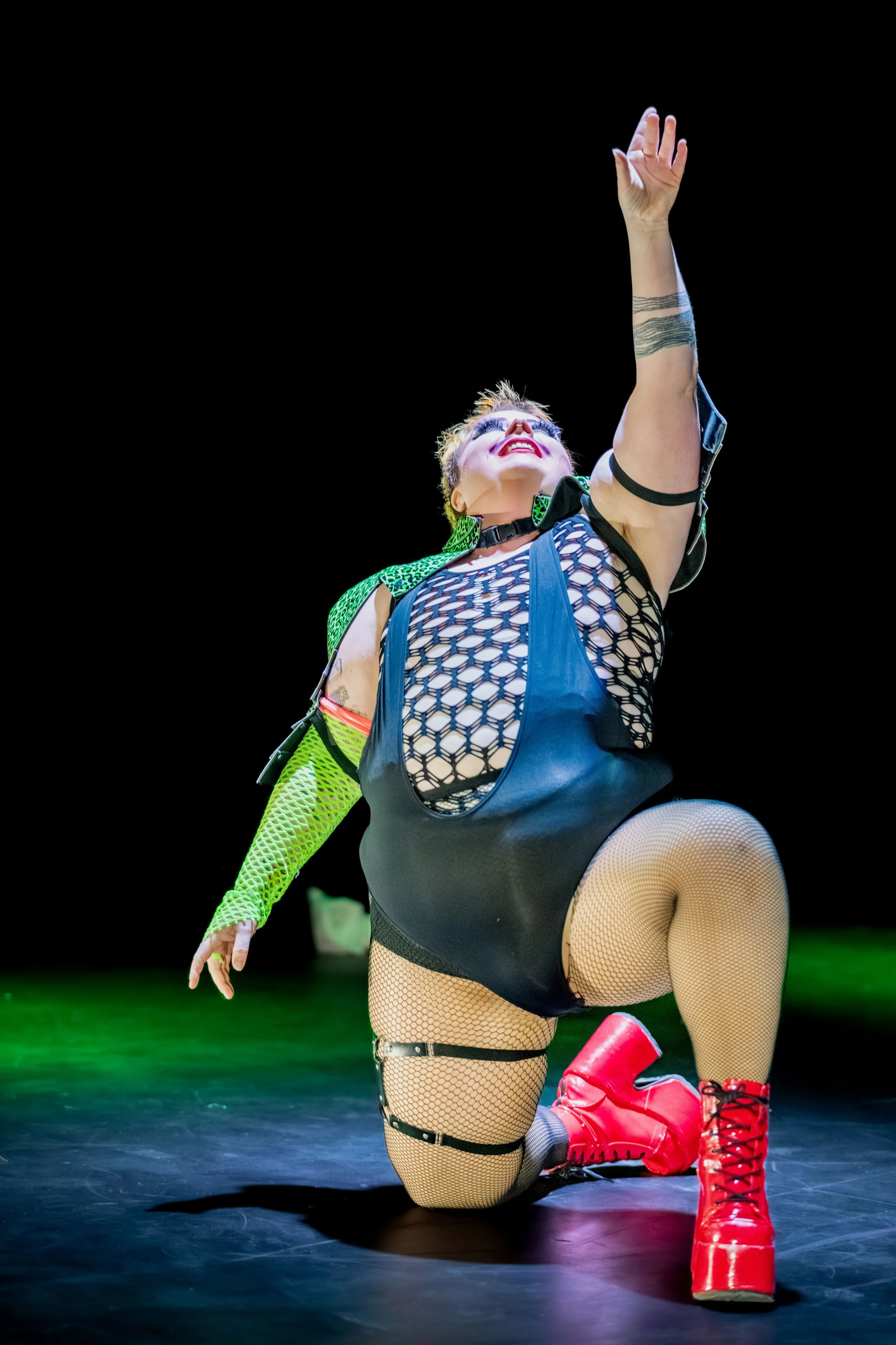 Jesse Dean takes a knee and raises a hand to the sky.