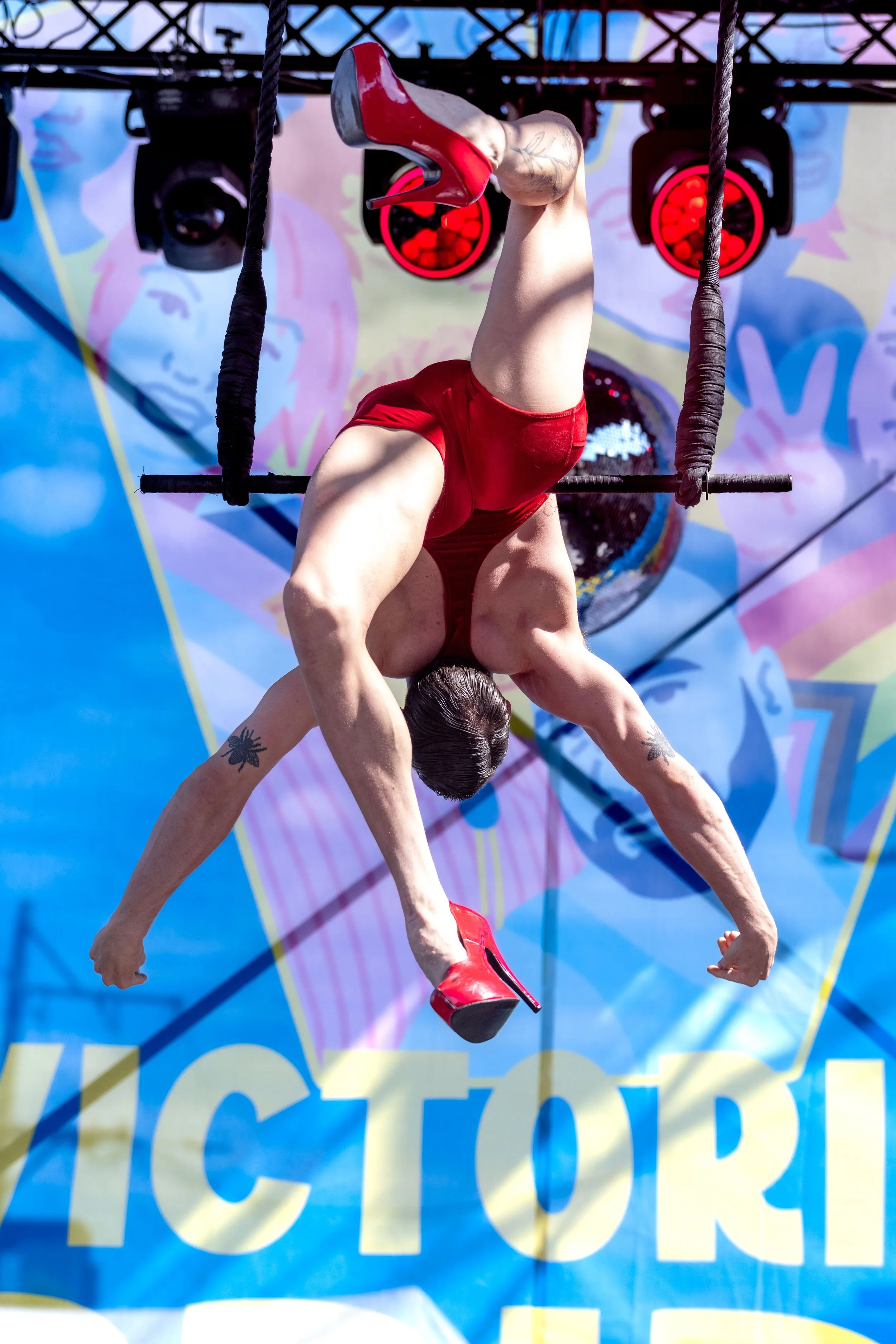 Jarred Dewey leans back on the trapeze without holding on.