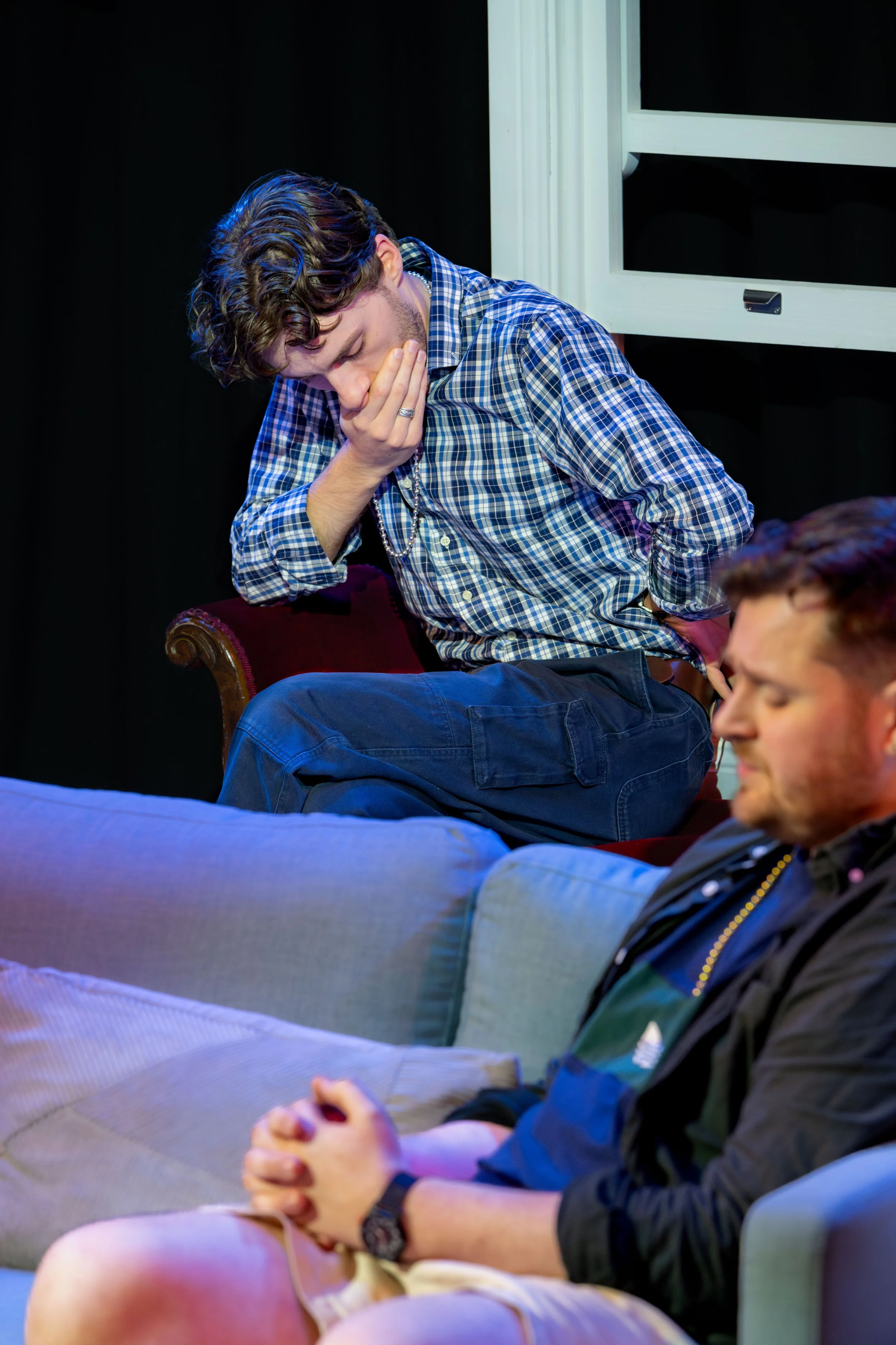 A human leans away with their mouth covered by their hand.