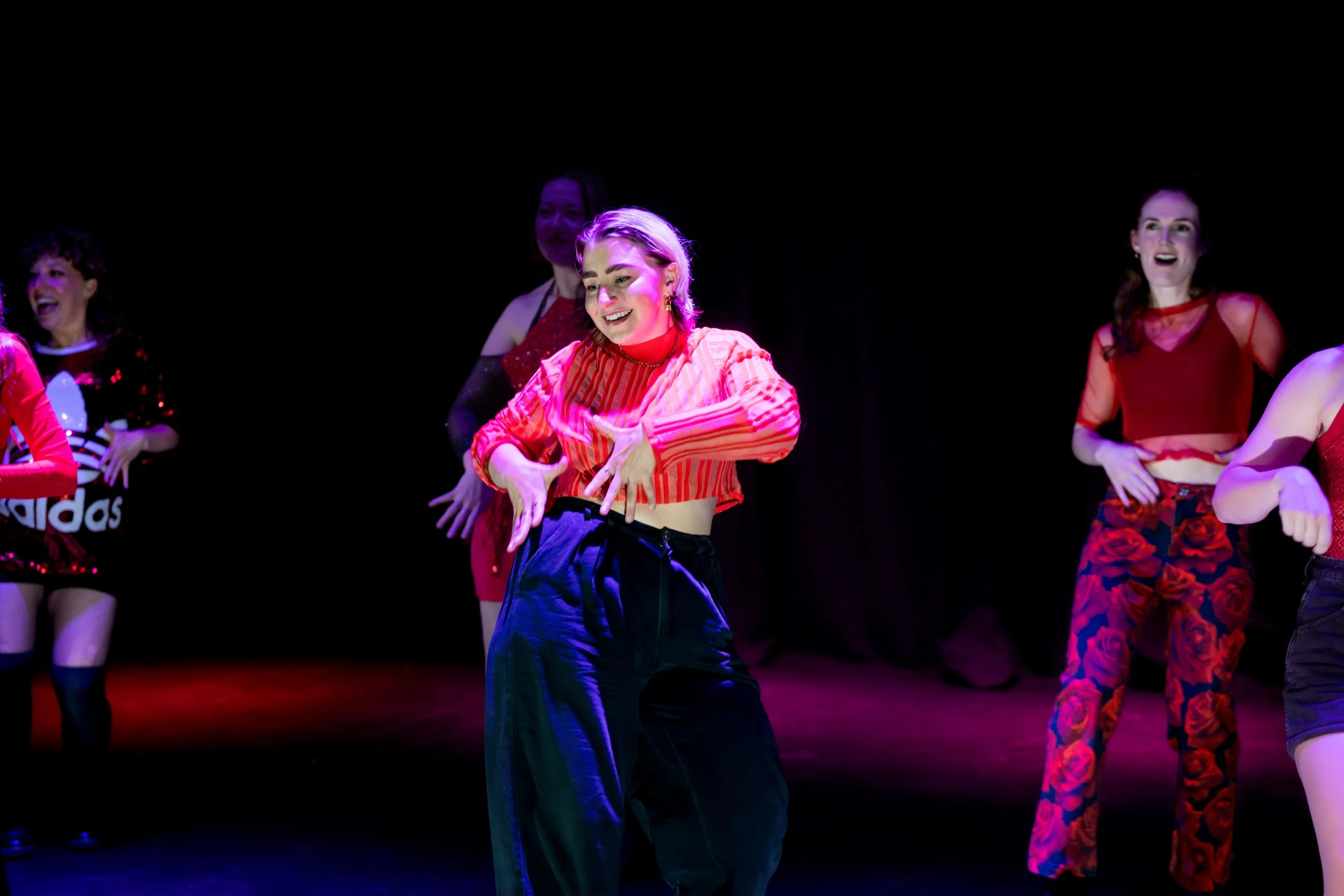 Dancers in red outfits on stage.