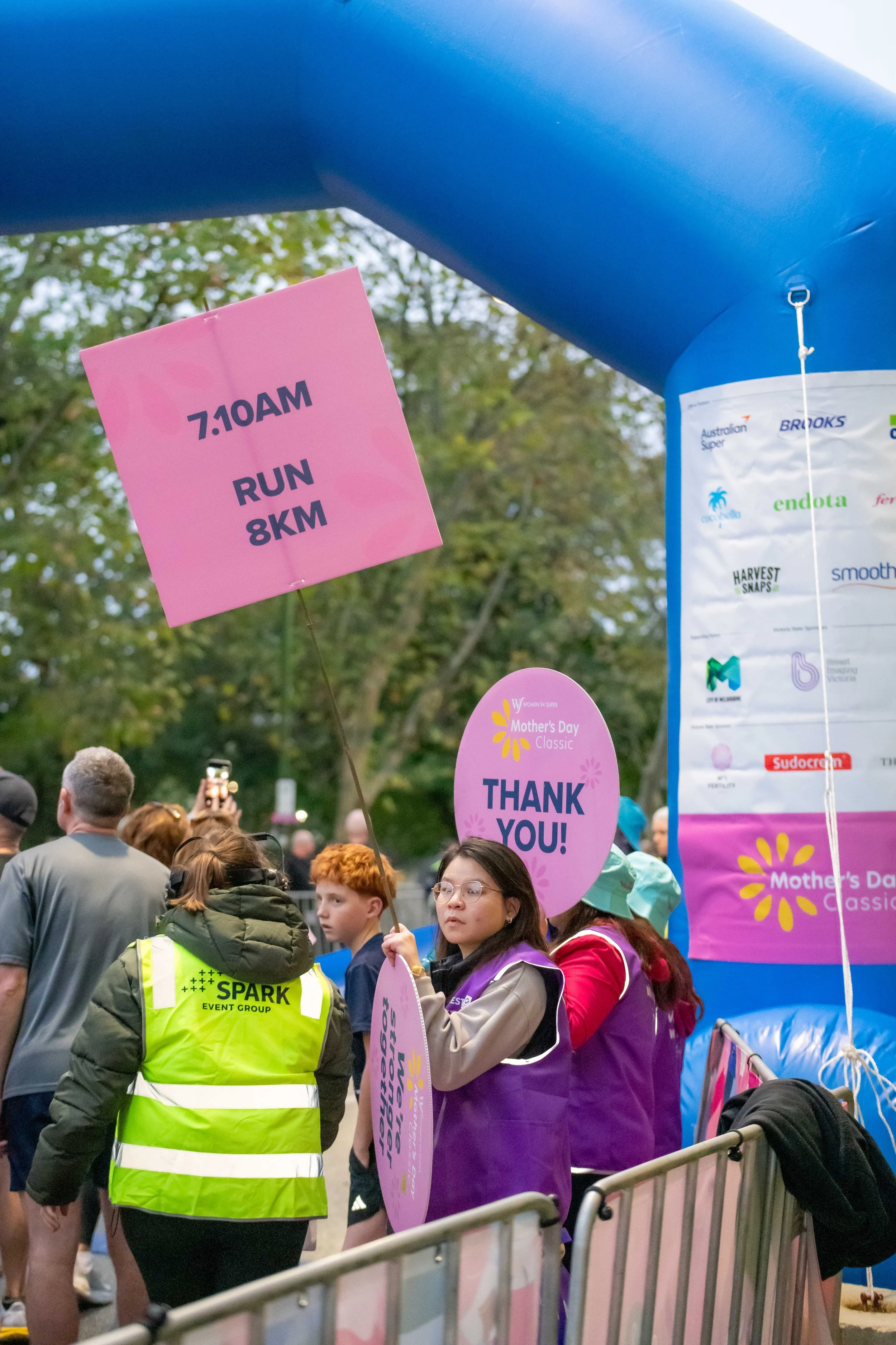 Volunteers holding up race signs at the start line.