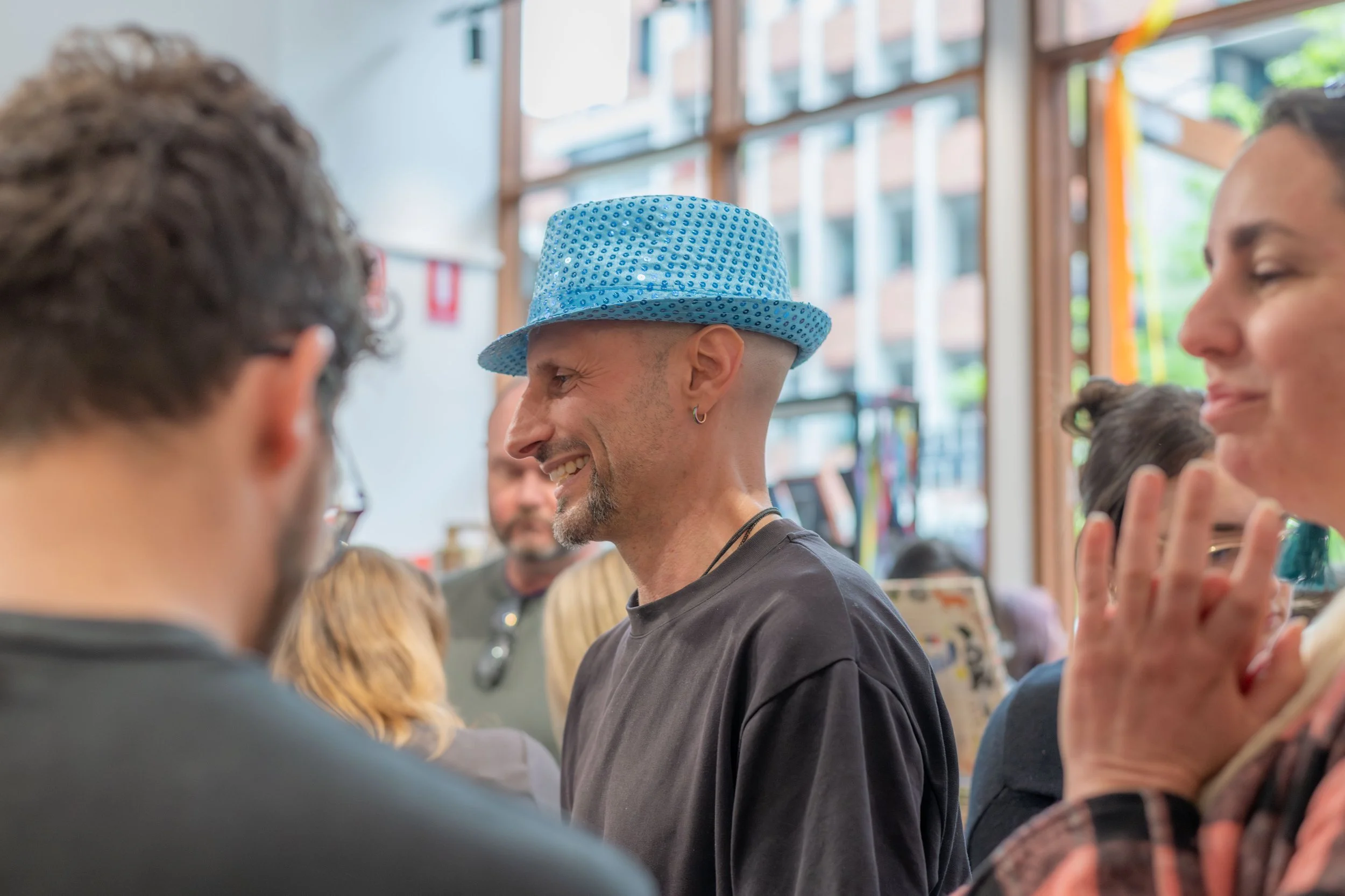 An author in a blue sparkly hat smiles.