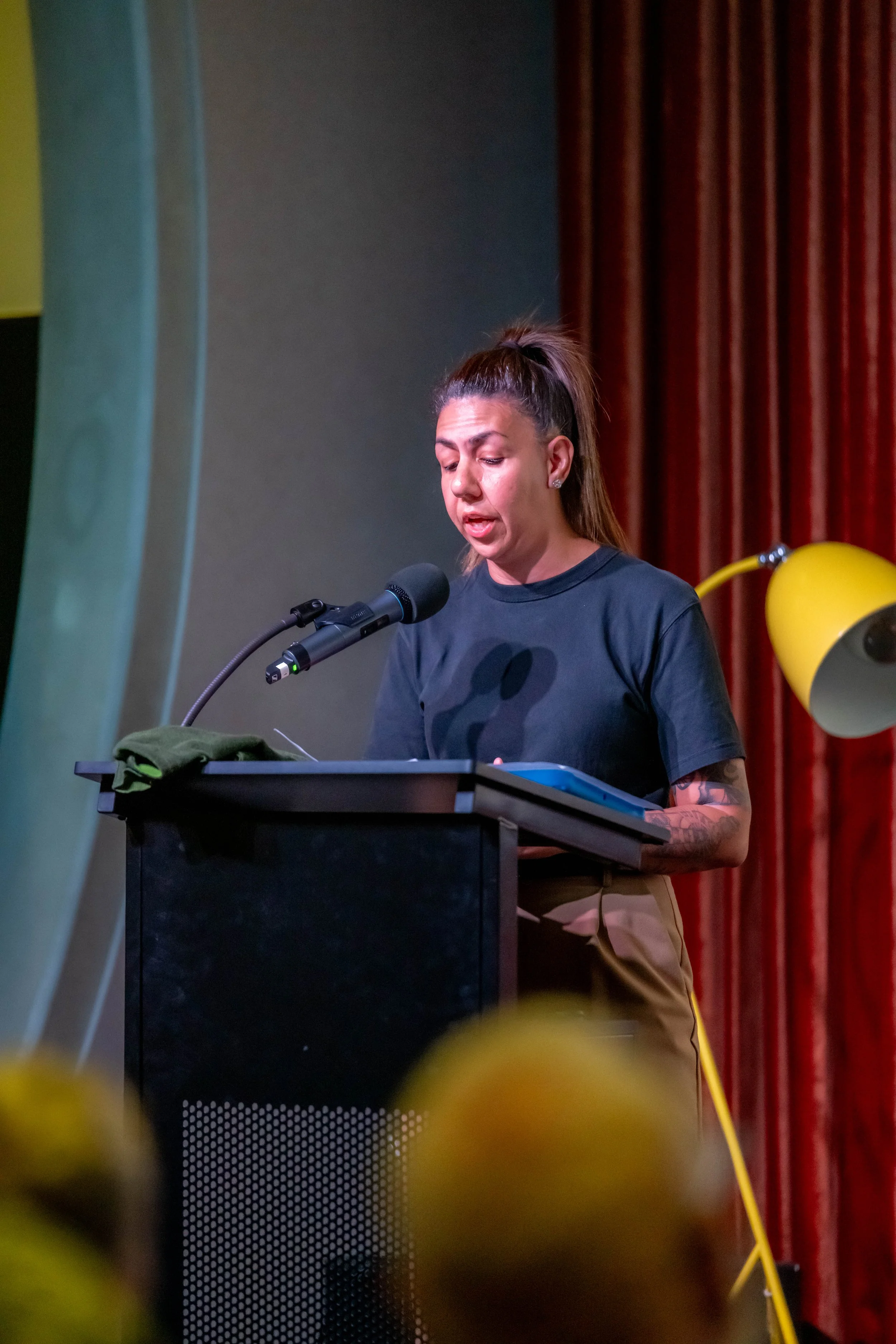 A human wearing black speaks at a lecturn.