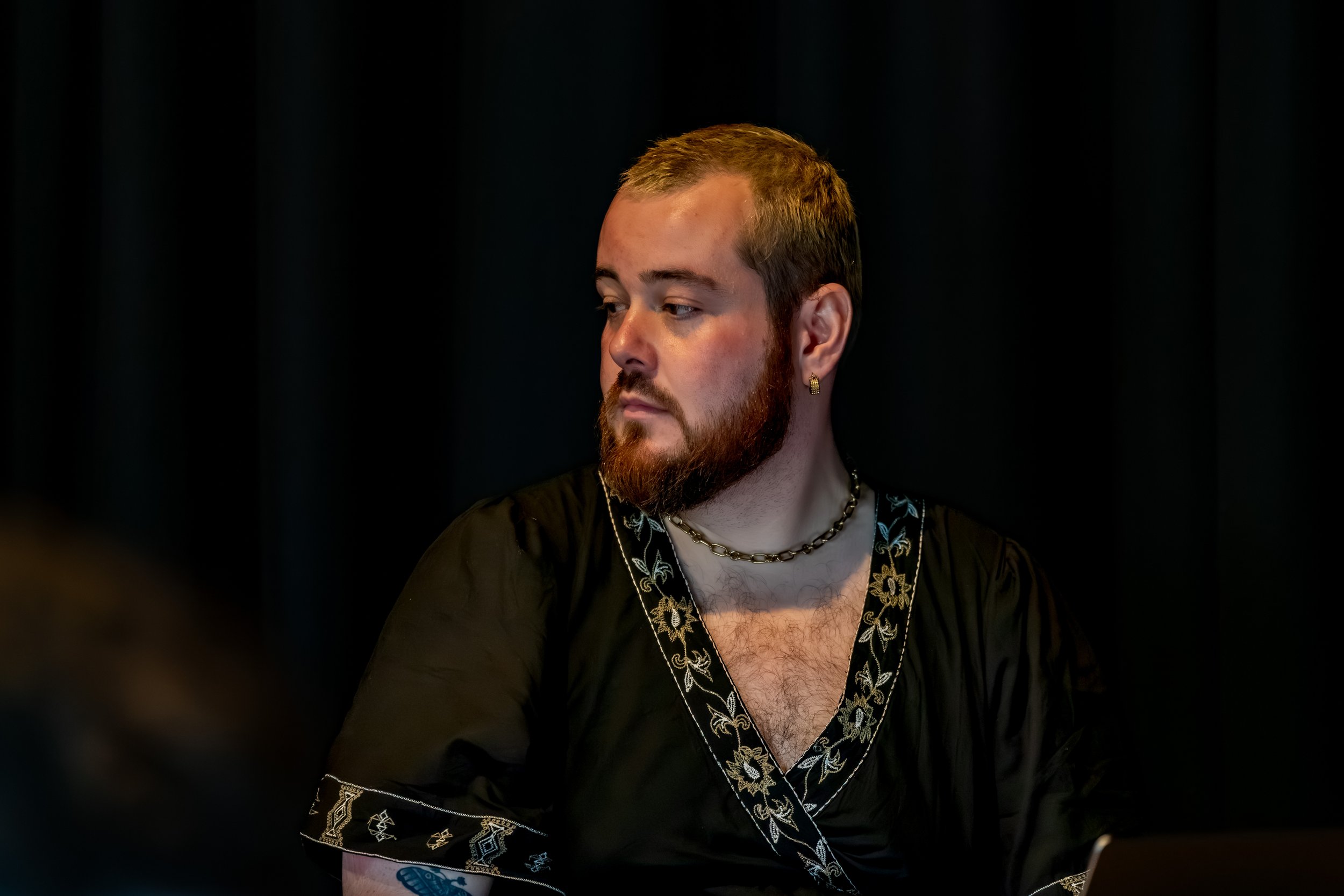 A human with a red beard looks to their right.