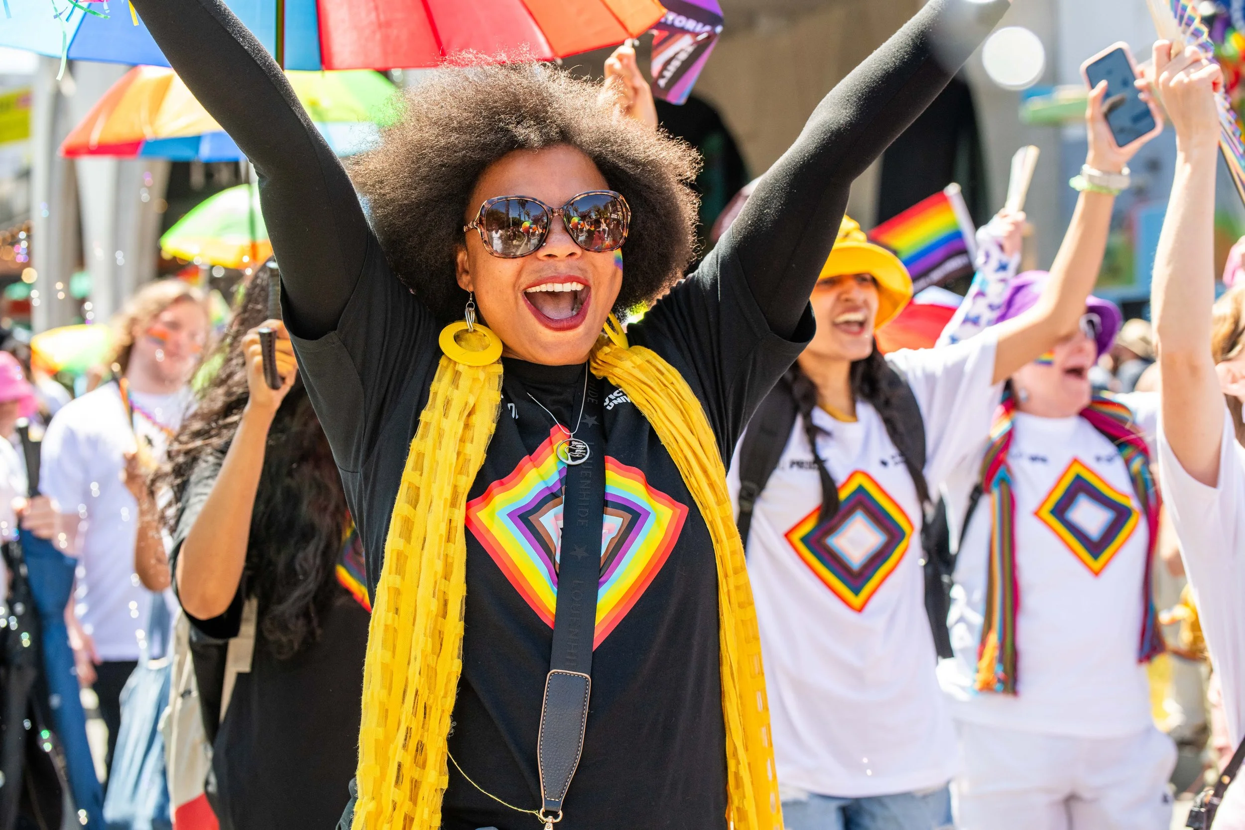 A human wearing sunglasses raises their hands in the air.