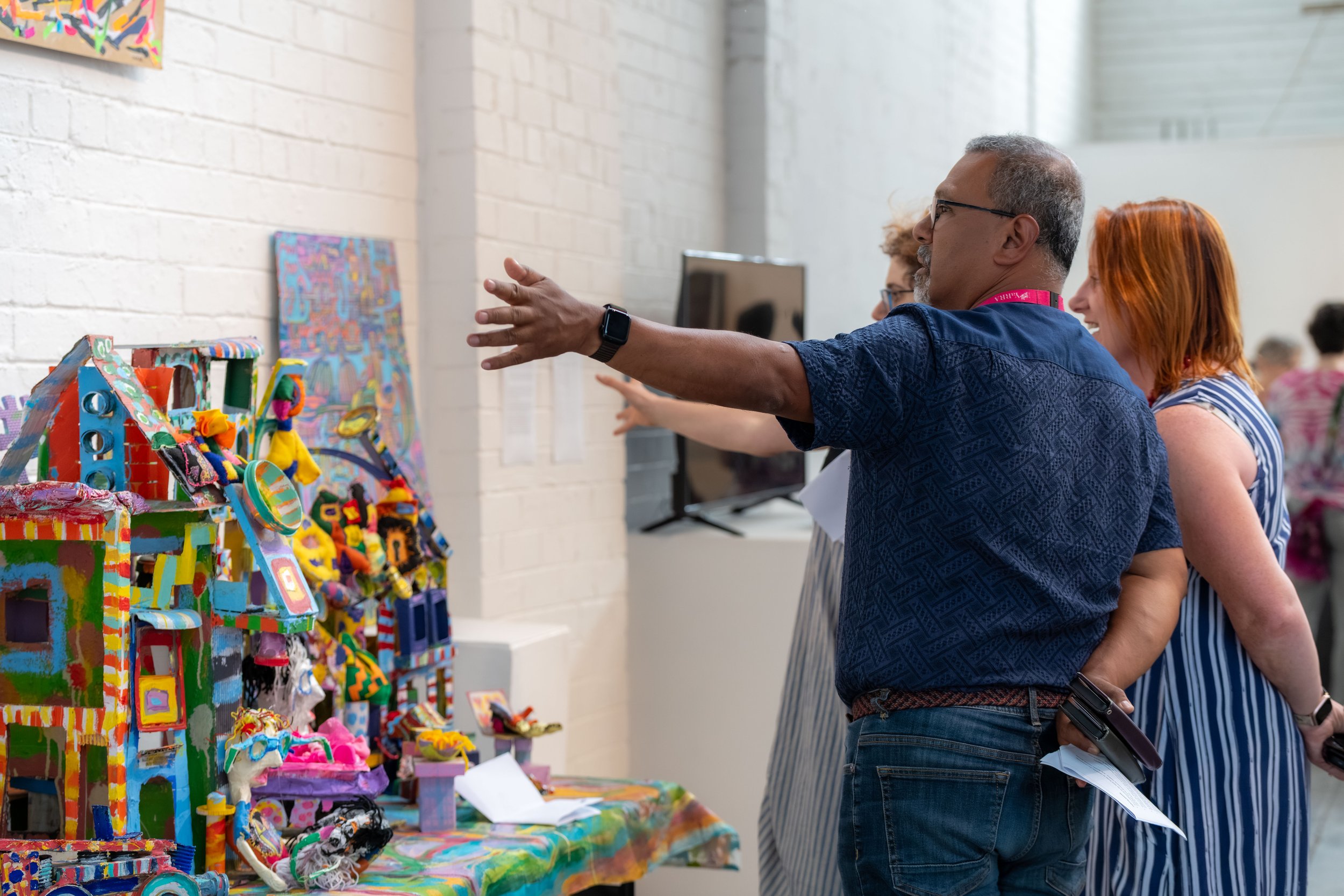 Councillor Ken Gomez points at colourful artwork.