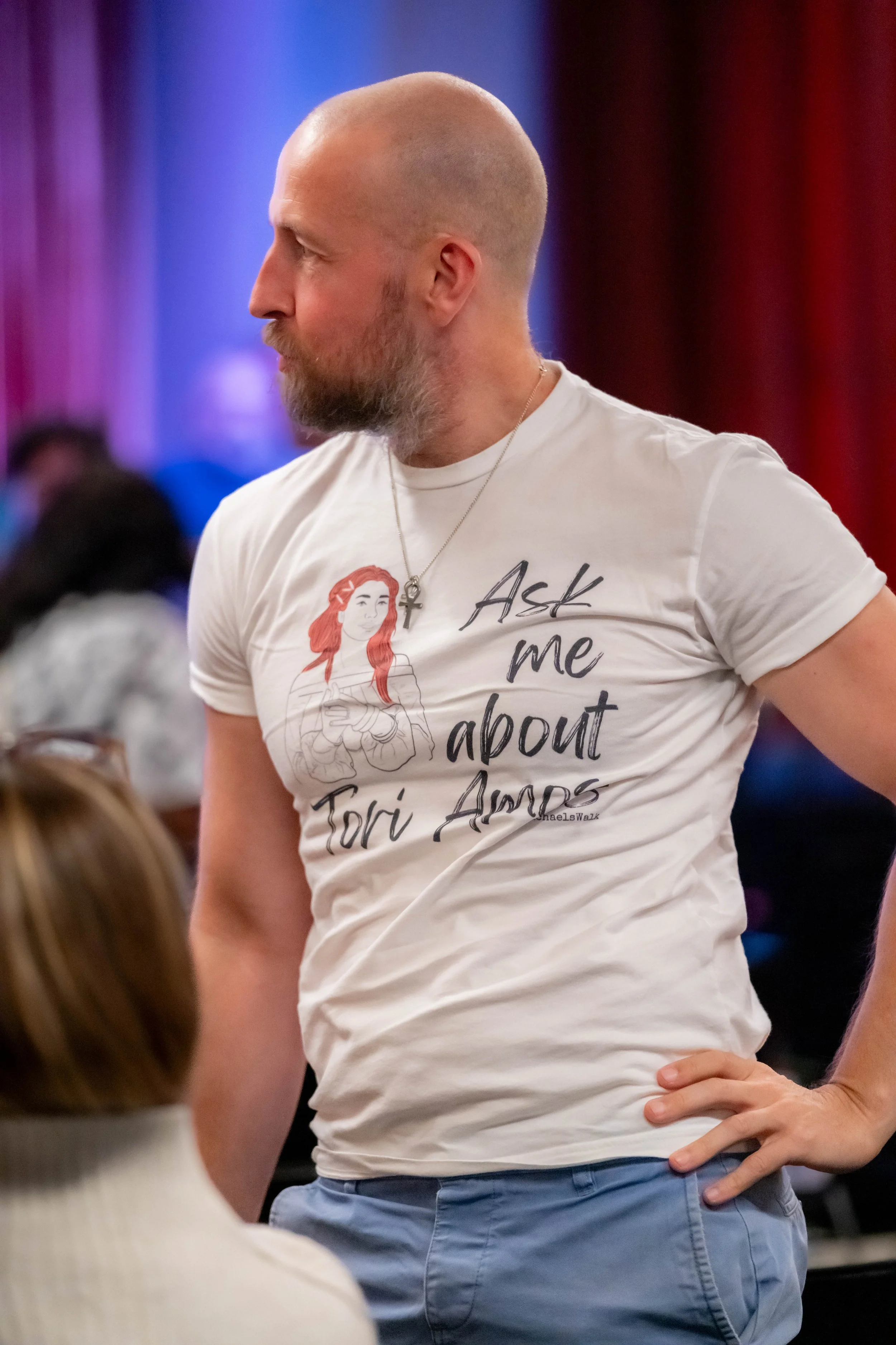 A human wears a white tee that has "Ask me about Tori Amost" on it.