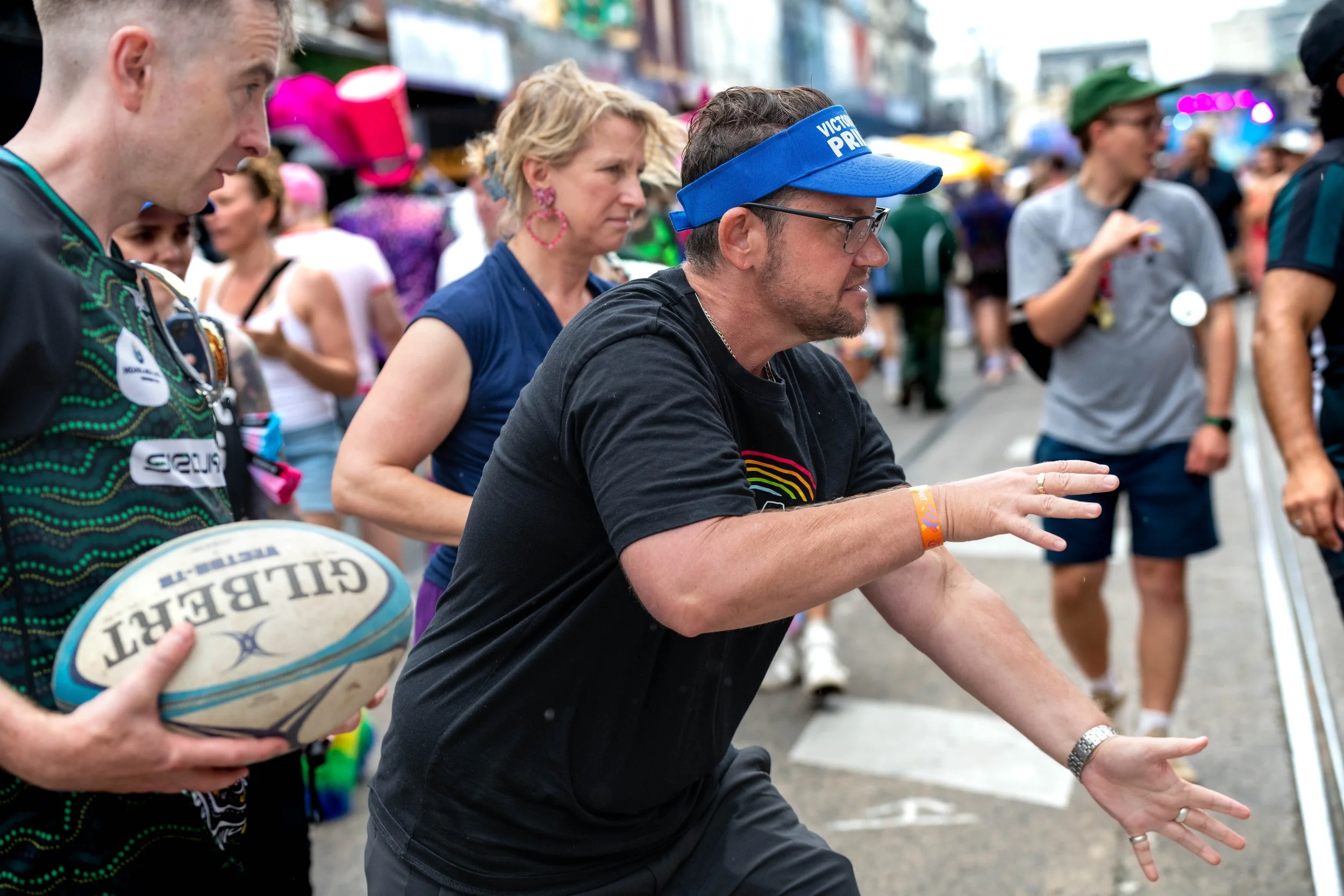 Joe Ball, Victorian Commissioner for LGBTIQA+ Communities, throw a rugby union ball.