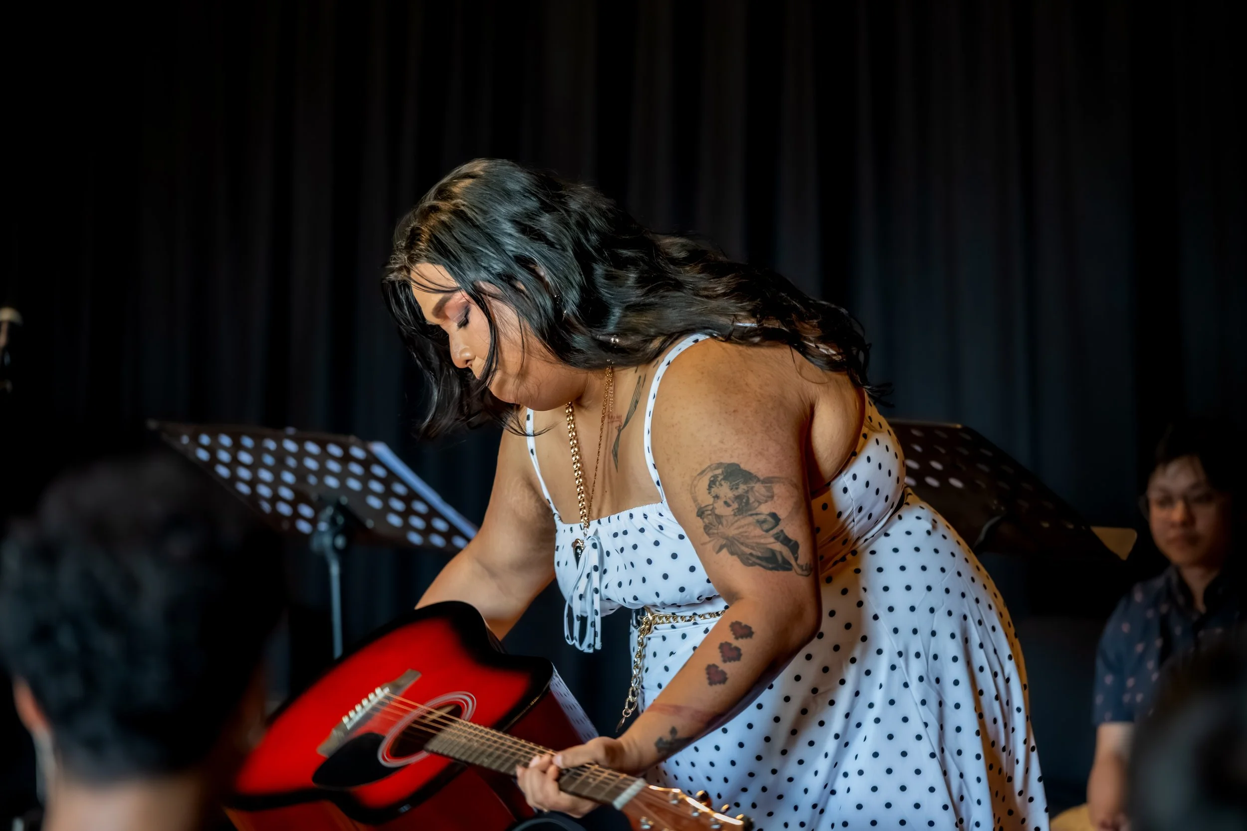 A human places a guitar in its case.