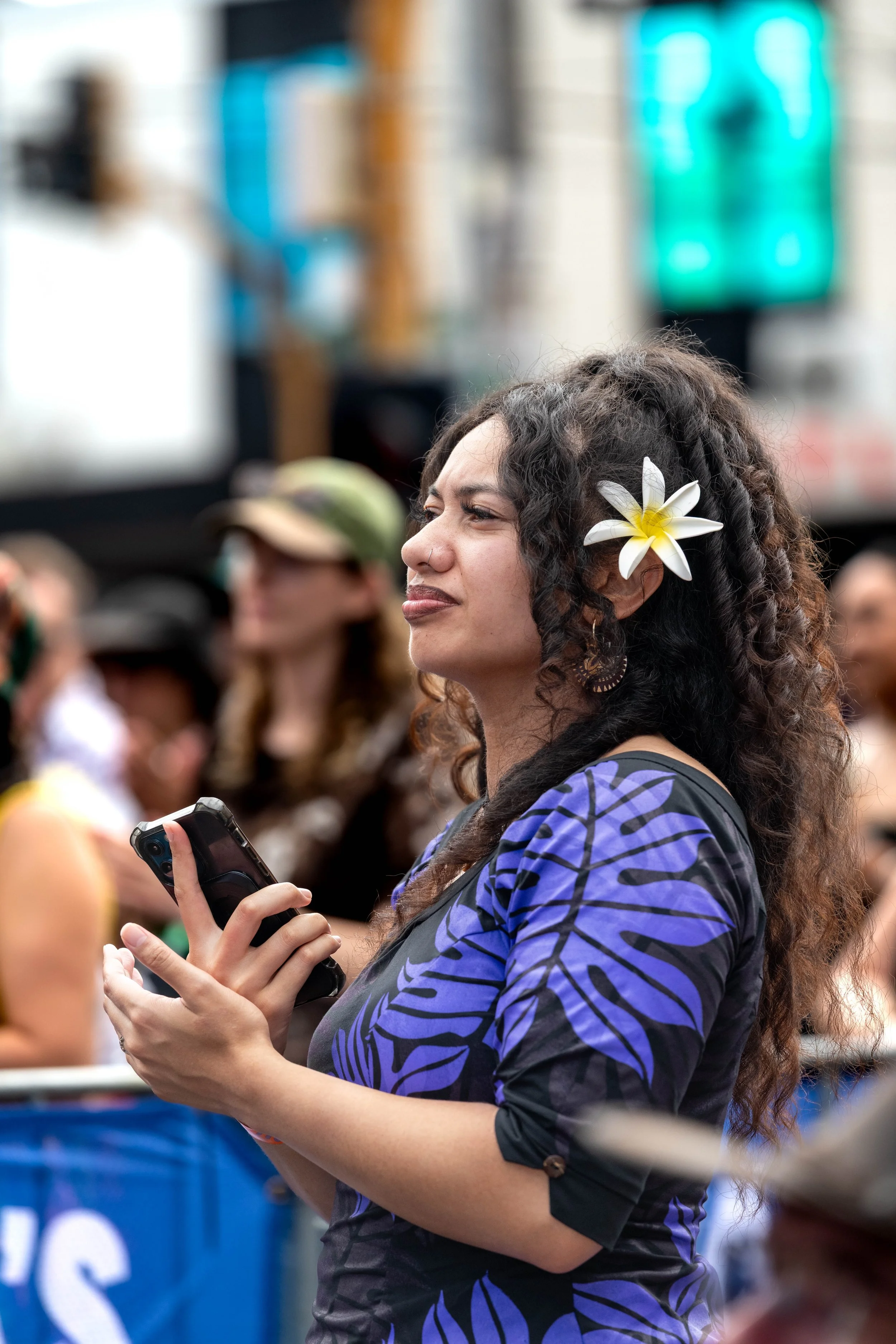 An audience member watches the main stage. They wear a flower in their hair.