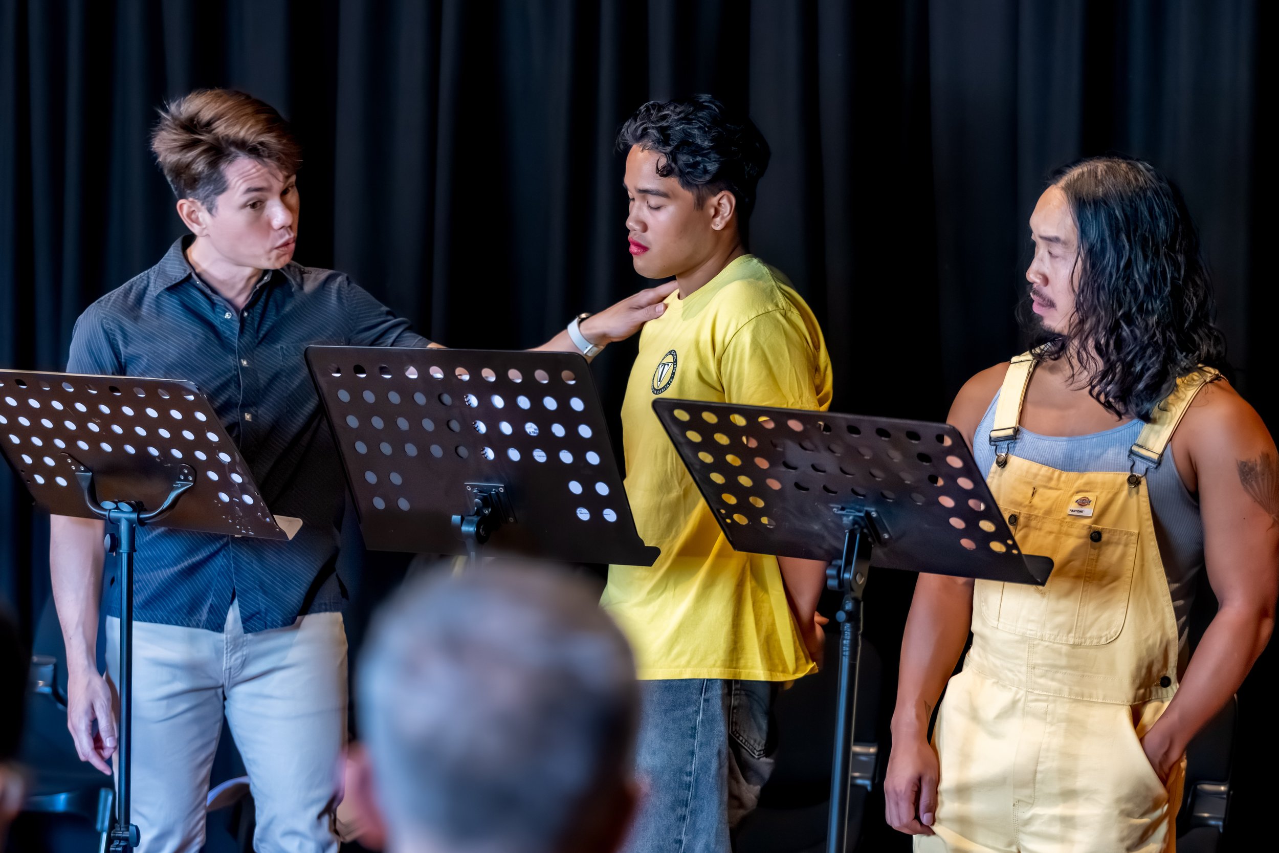 Three humans, one holds onto another ones shoulder.