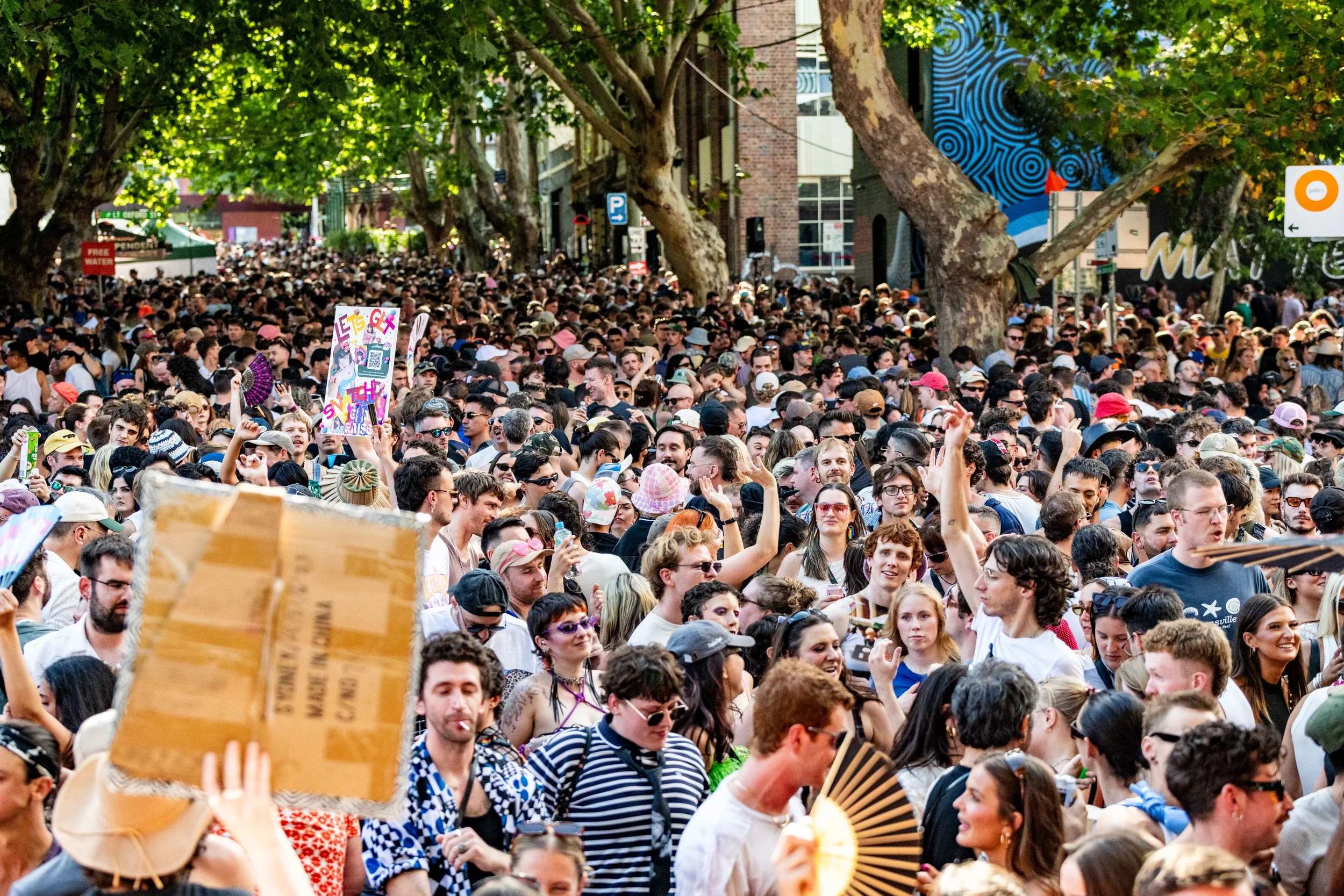 A massive crowd dances in the street.