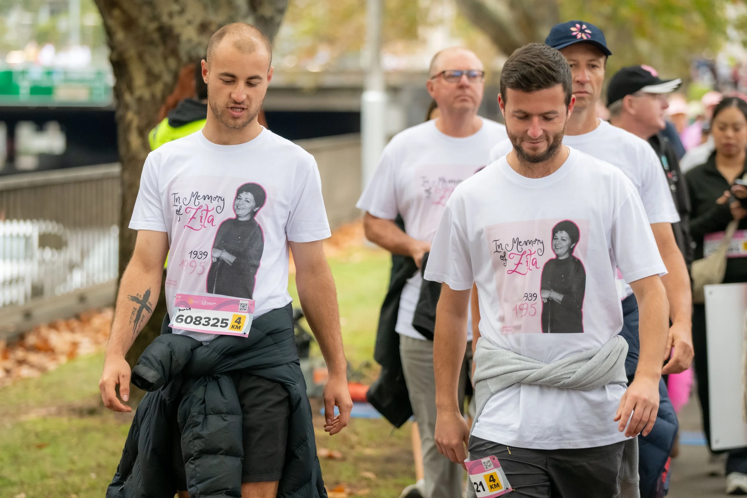Two racegoers wear white memorial tees.