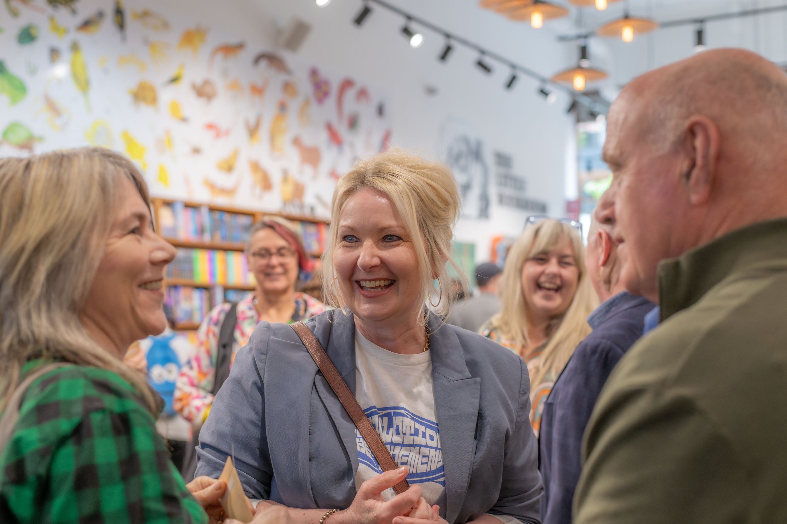 Three humans chat and smile at each other.