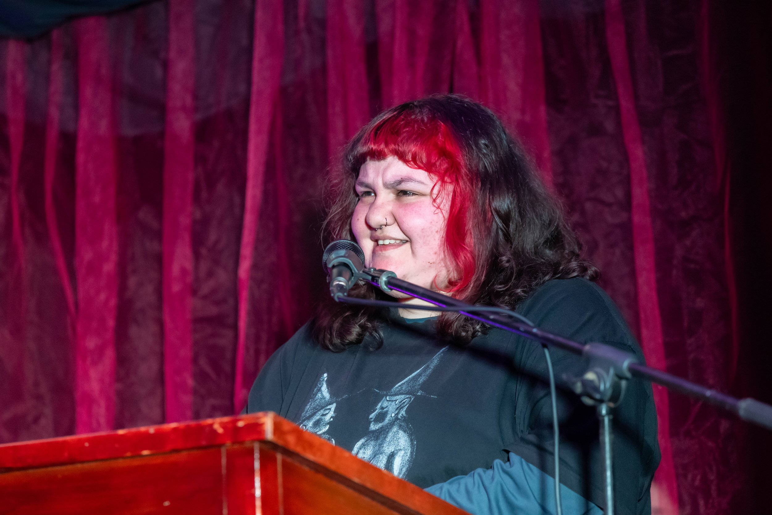 Skye Cusack smiles behind a microphone.