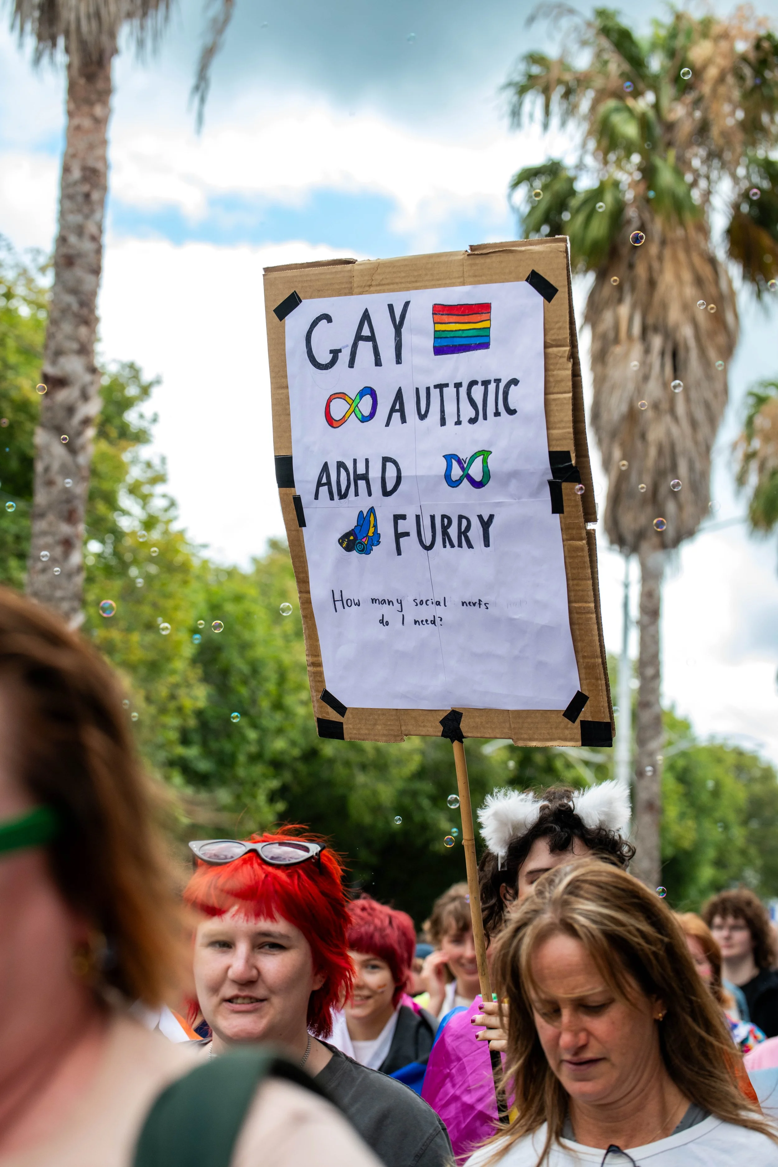 A placard "Gay, autistic, ADHD, Furry".