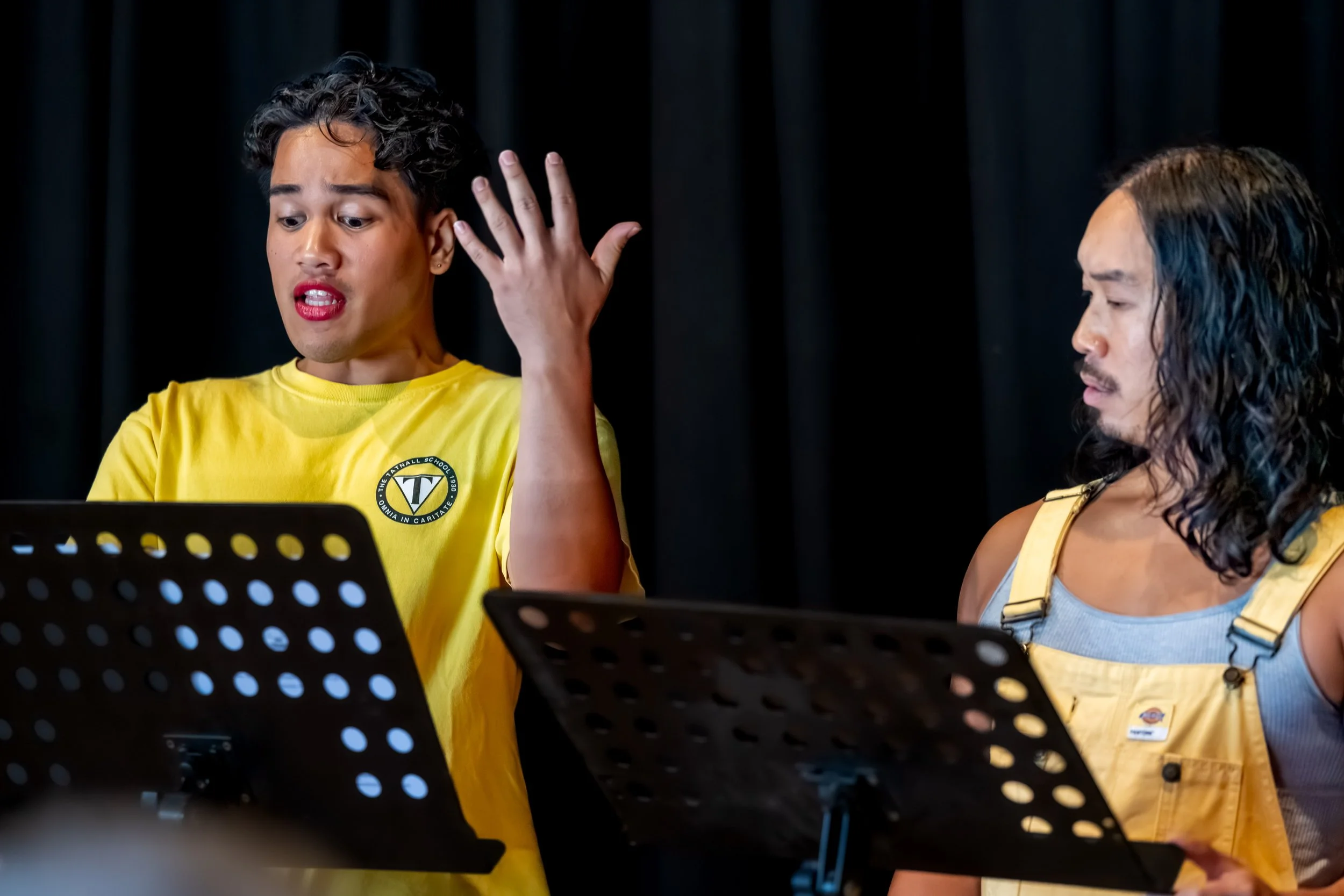 A human in a yellow tee gesticulates with their hand.