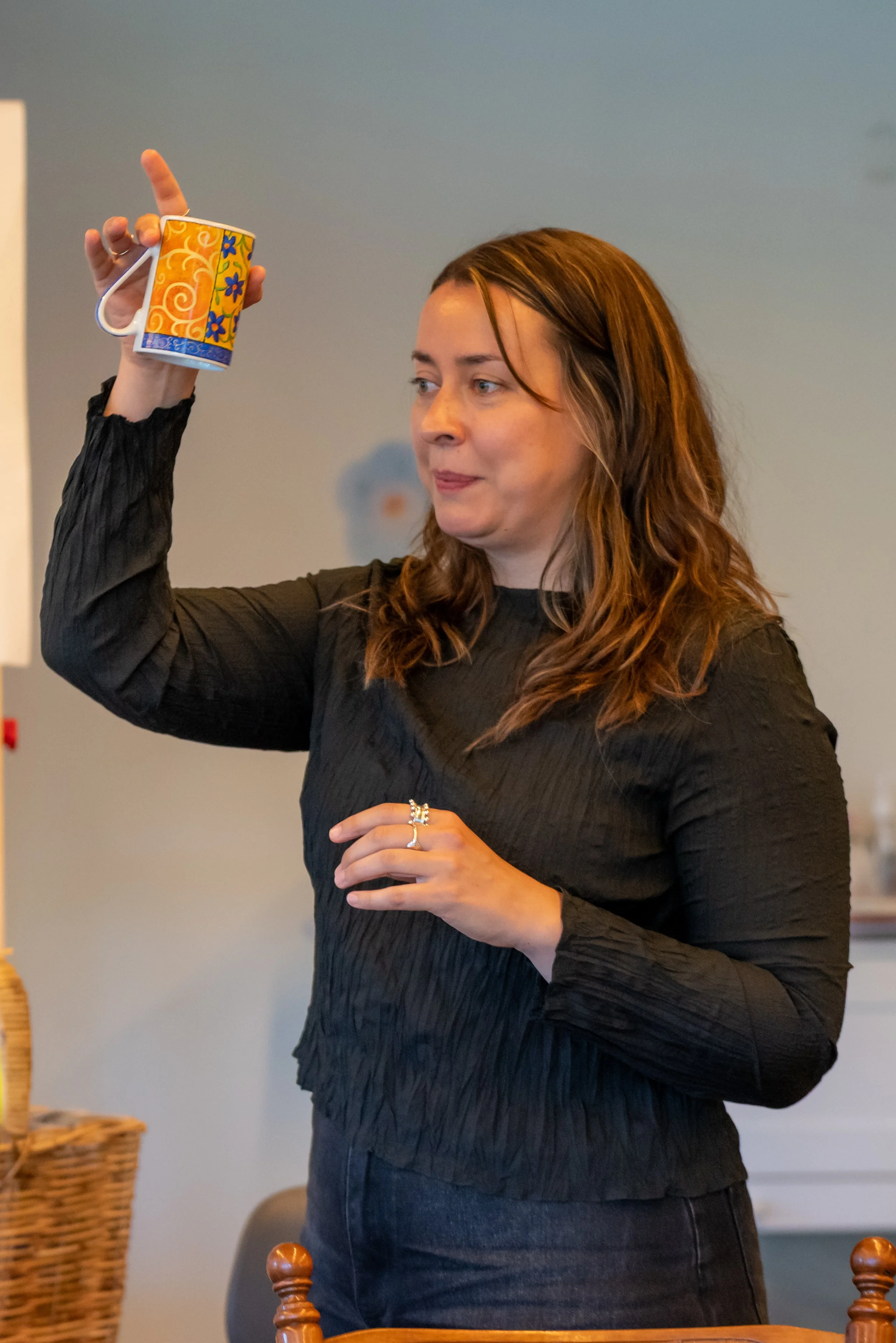 A human stands and tips a mug upside down; there is nothing inside it.