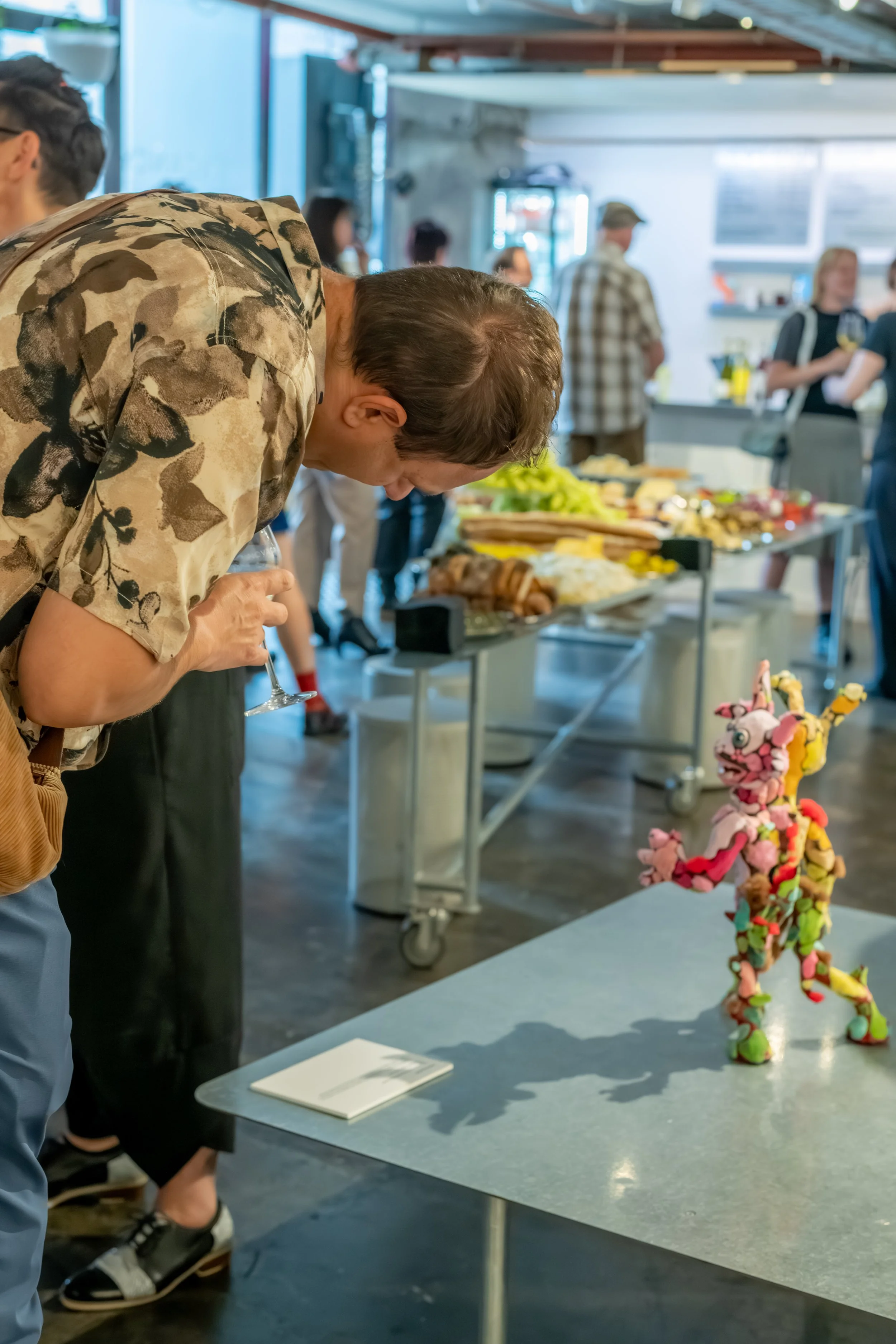 A human bent over reading the description of nearby artwork.