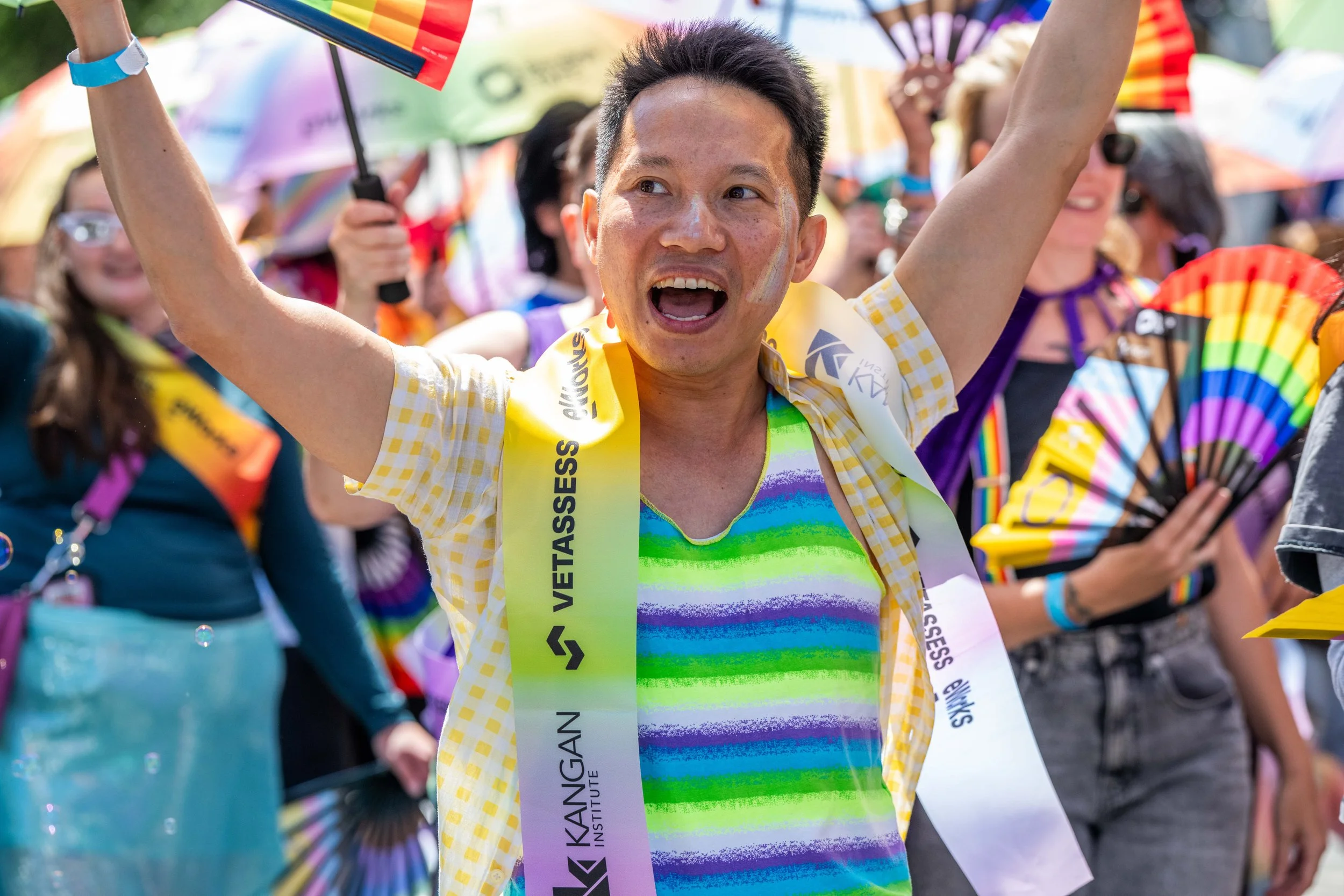 A human wearing face paint raises their hands in the air.