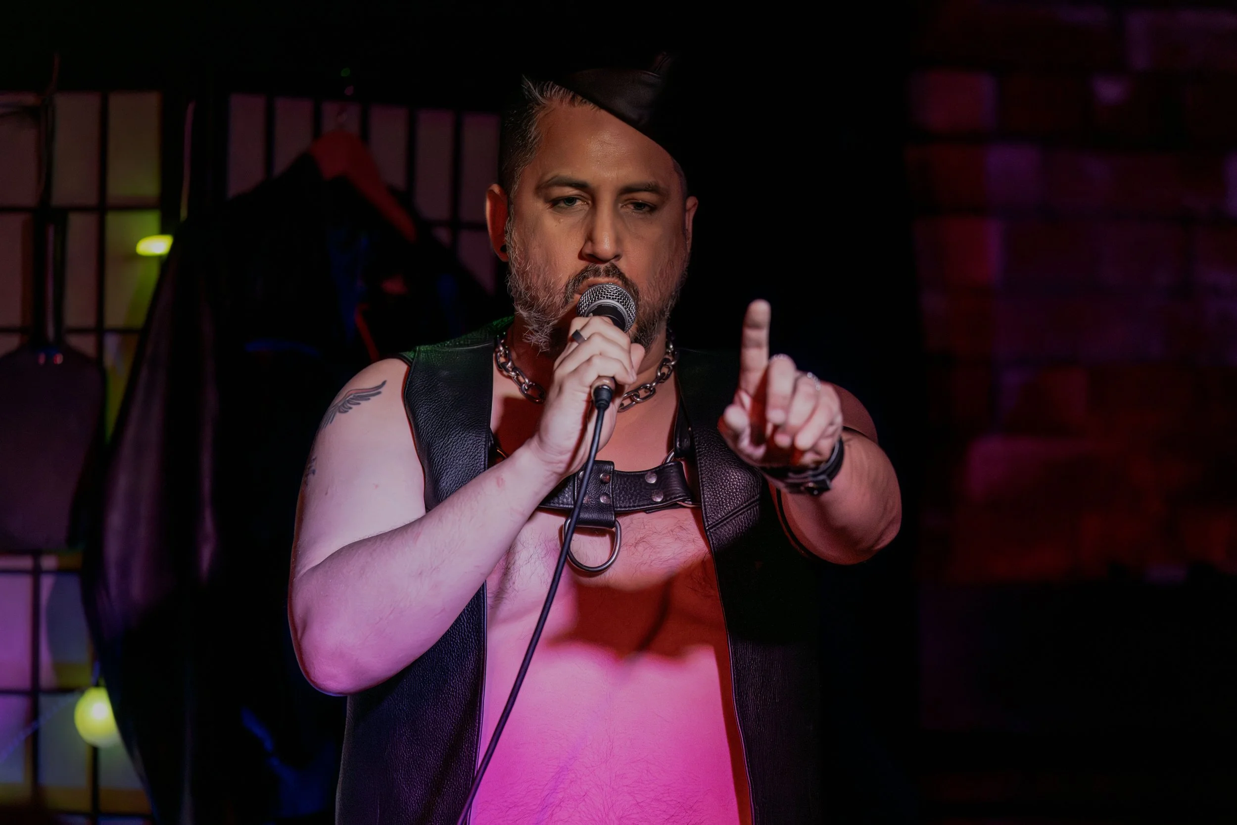 Andrew Rose holds a finger up to the audience.