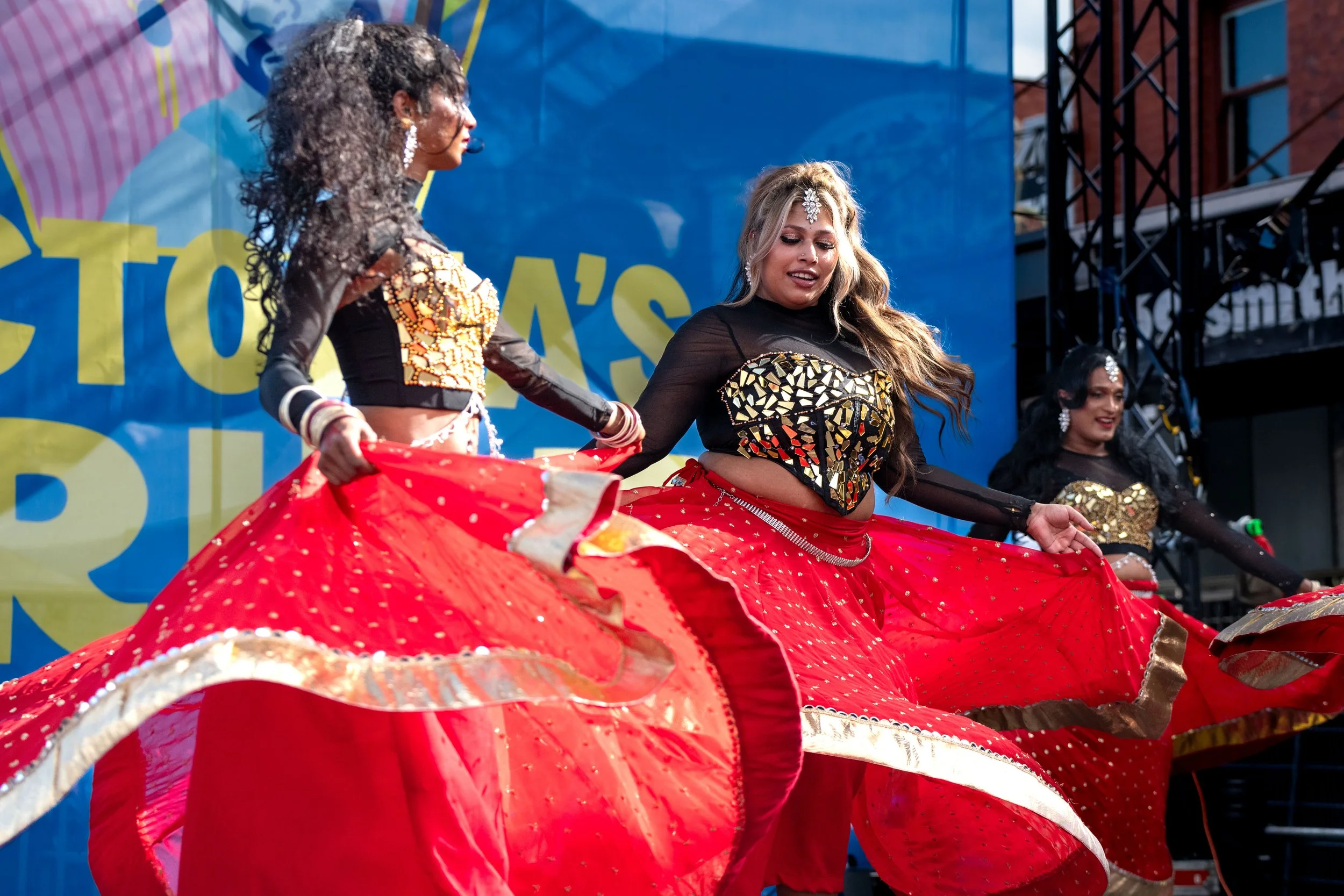 Dancers from Karma Dance spin their red glittery skirts about.