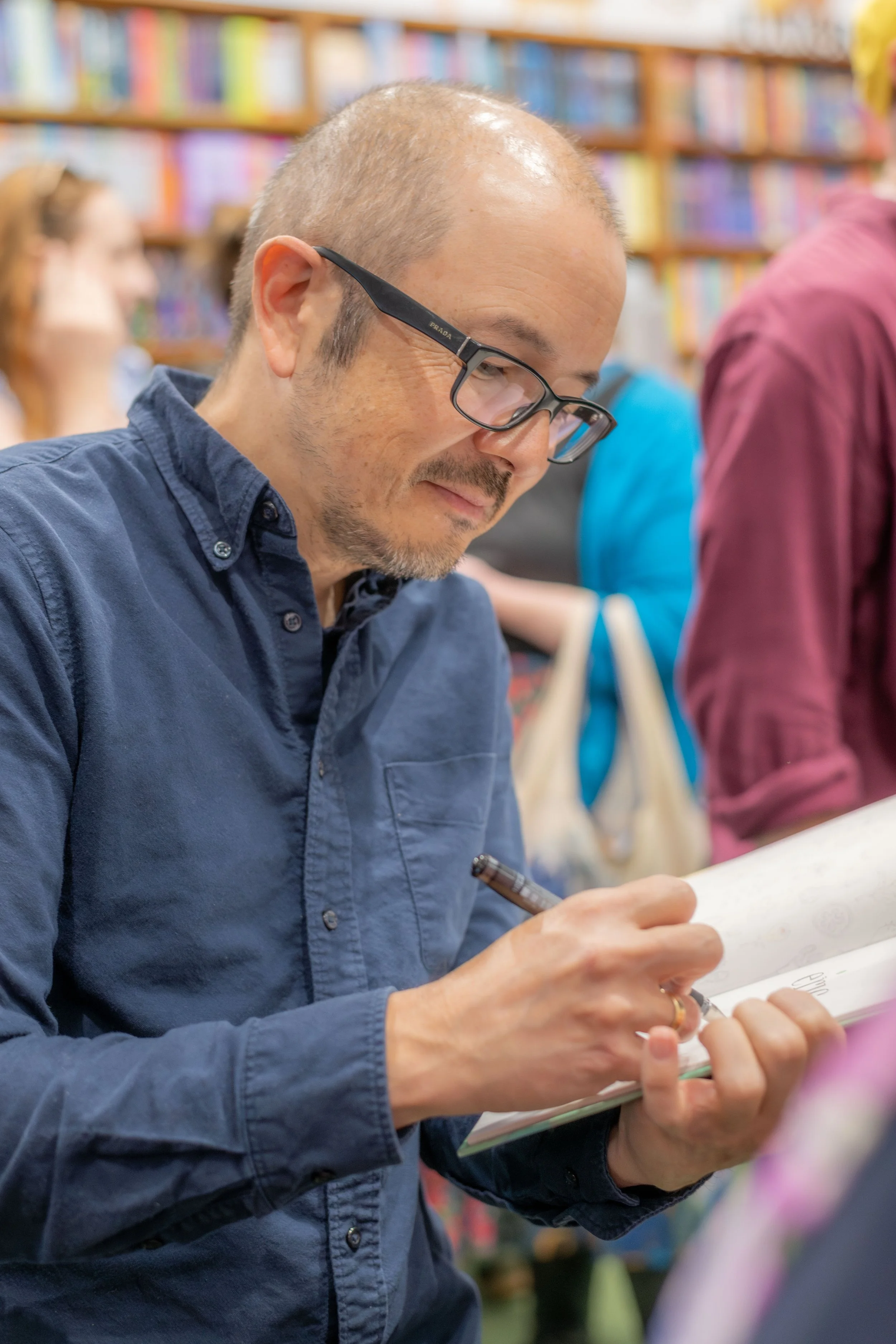 Shaun Tan signs a book.