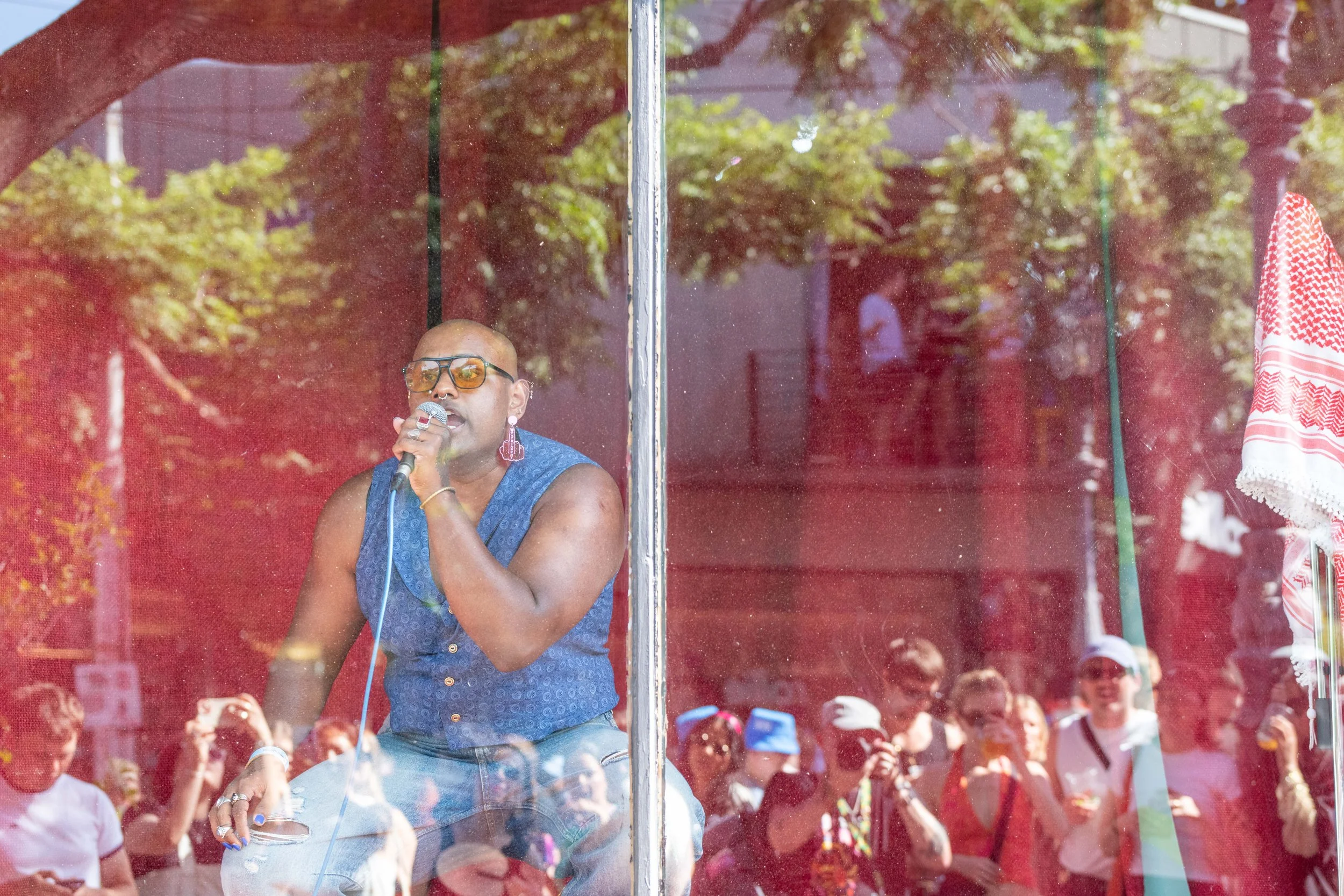 Goddess Naavikaran squats and sings behind a glass window.