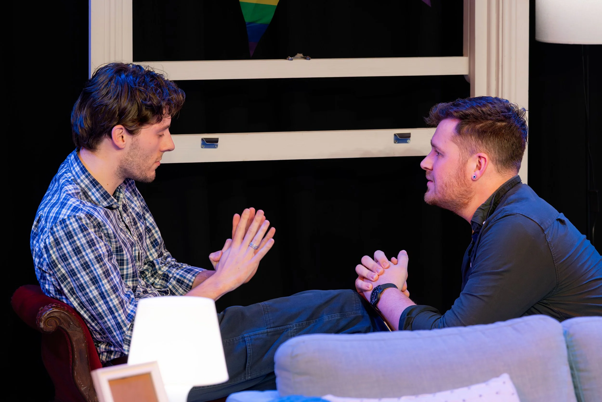 Two humans sit by a windowsill.