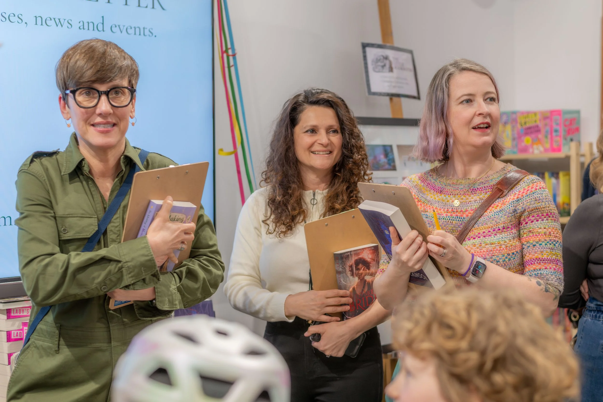 Three authors stand together, holding clipboards.