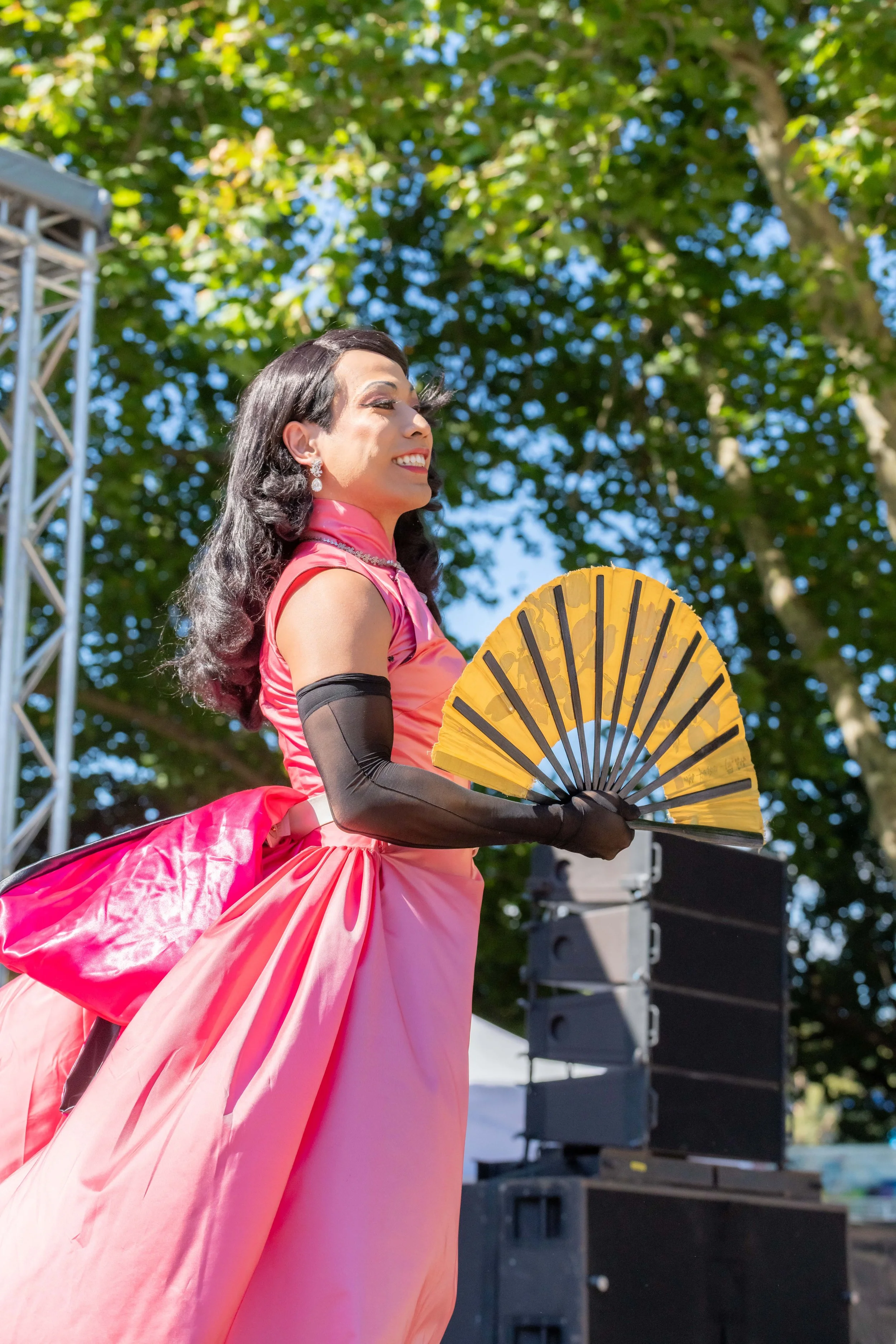 So Hung Son is dressed in pink and uses an orange fan as they lipsync for the audience.