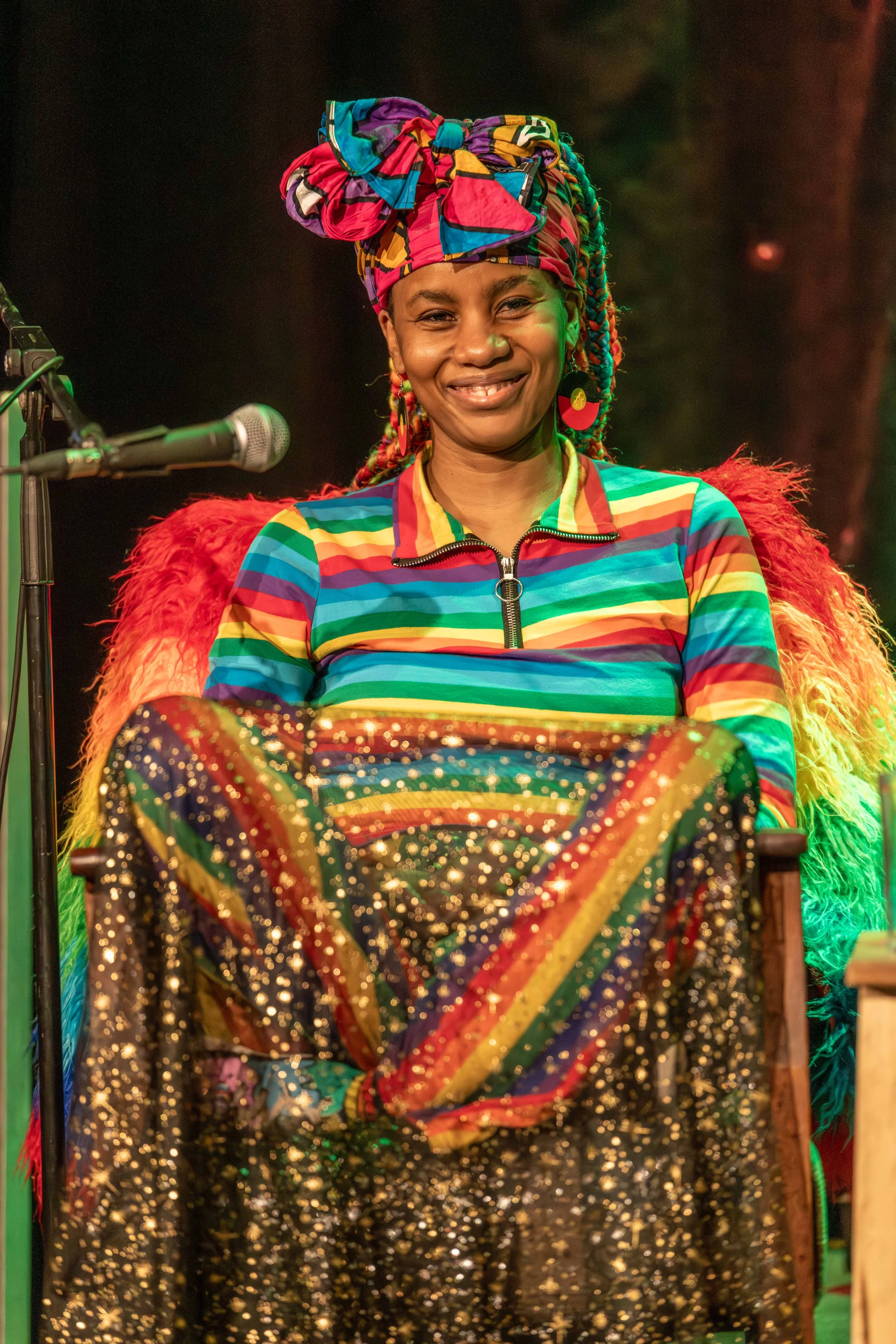 A human sits cross-legged and smiles warmly.