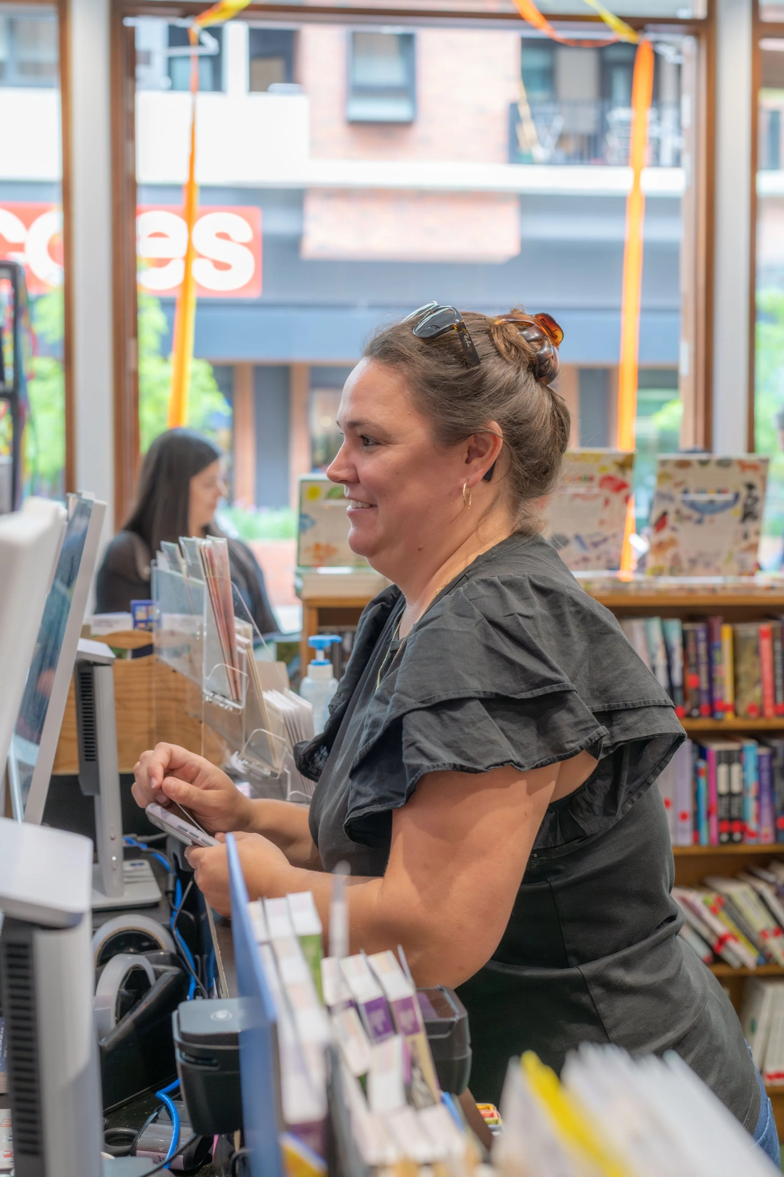 A human is at the counter buying a book.