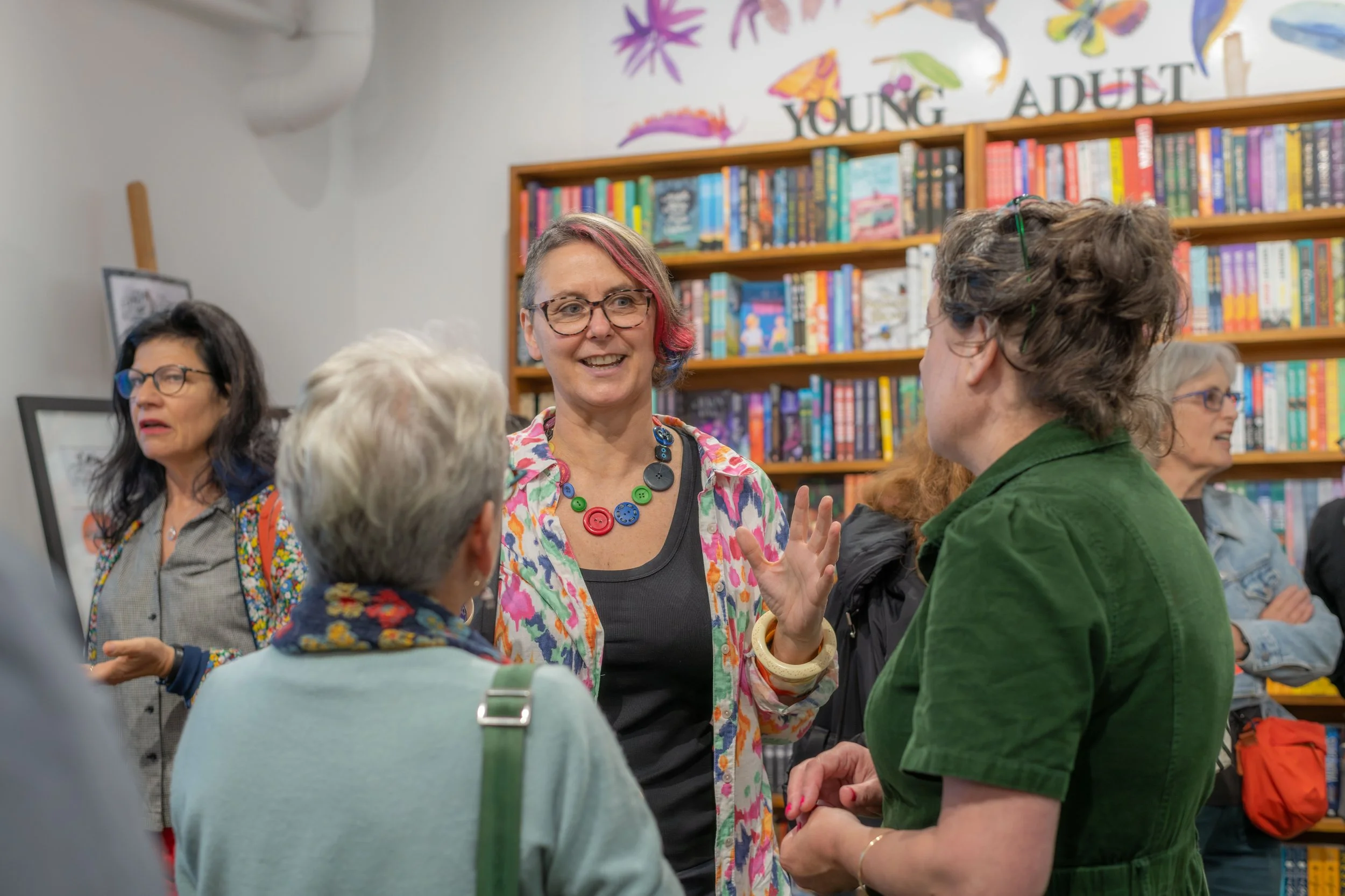 An author chats and smiles to others.